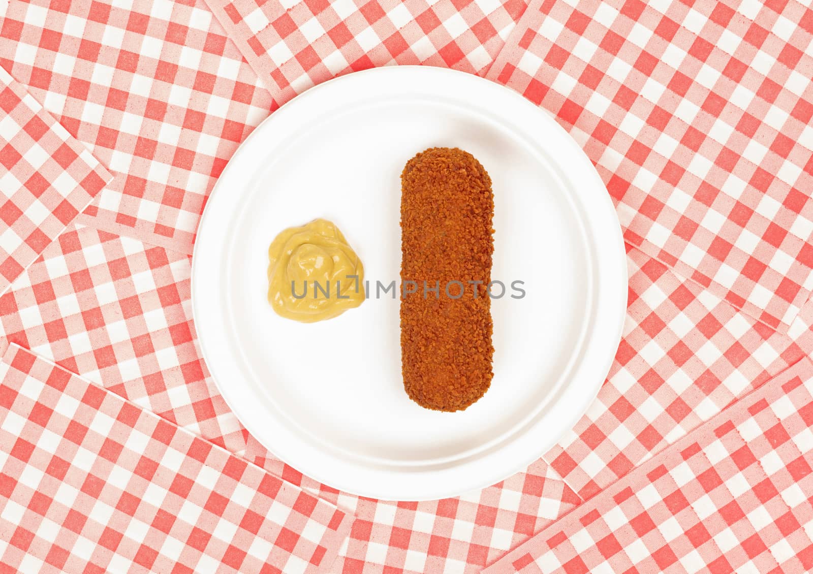 Brown crusty dutch kroket with mustard on a white plate isolated by michaklootwijk