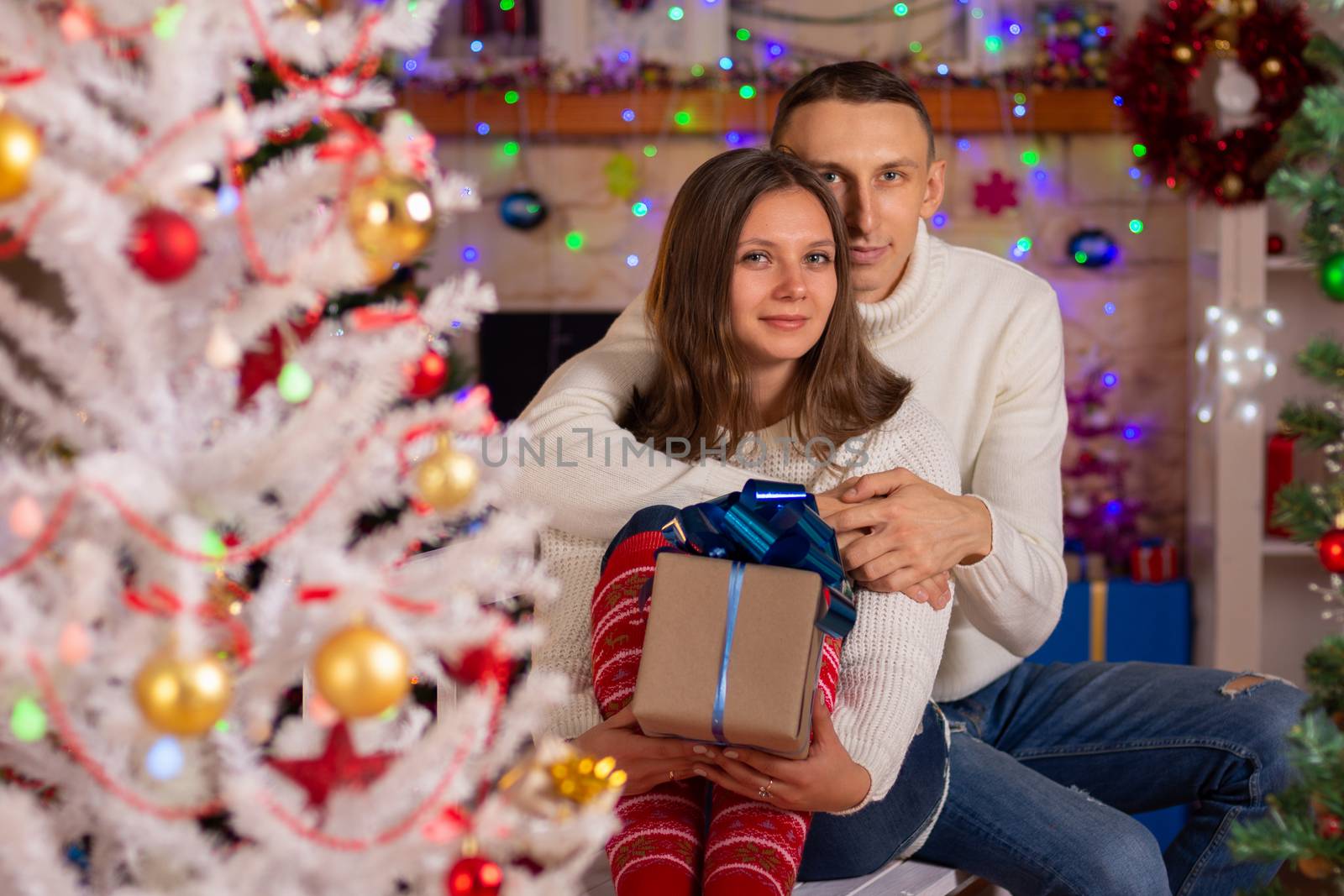 A couple in love with gifts near a Christmas tree