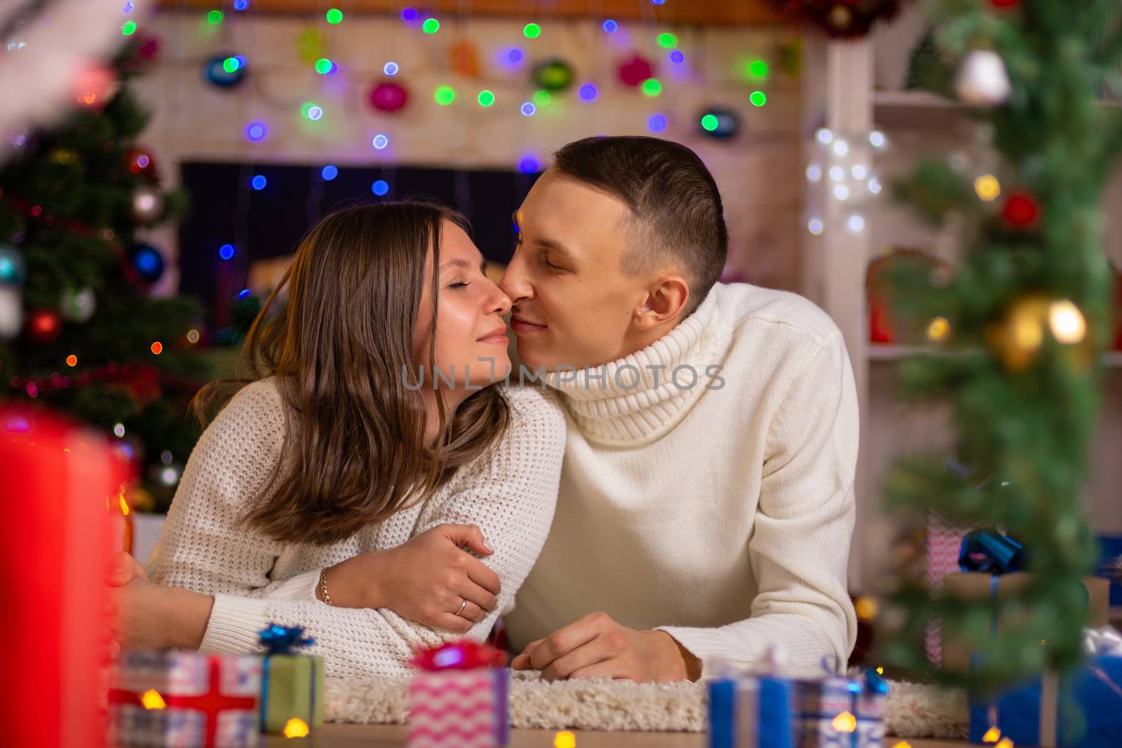 heterosexual couple hugs in a decorated room on Christmas day
