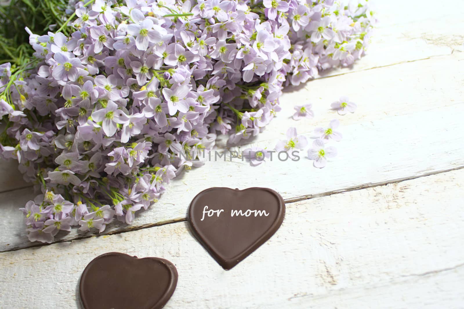 The picture shows cuckoo flowers and chocolate hearts