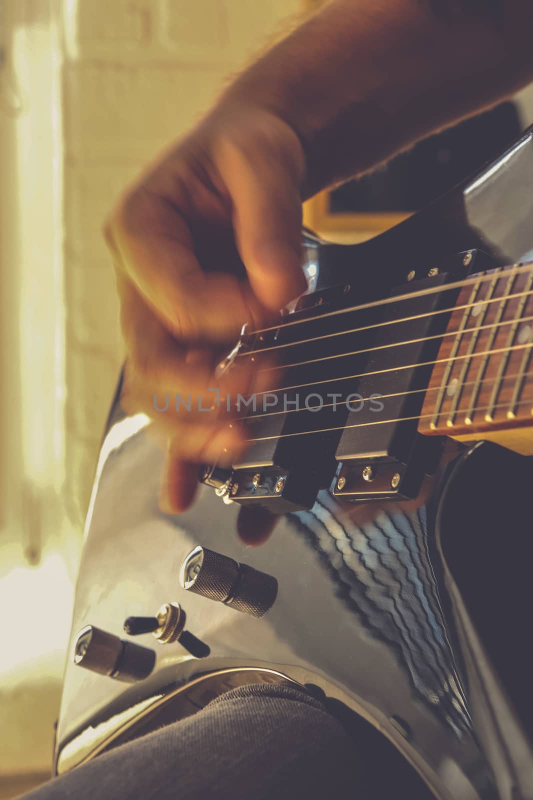 Playing the guitar. Guitarist's hand dynamic motion. Musical lifestyle background. Macro closeup.