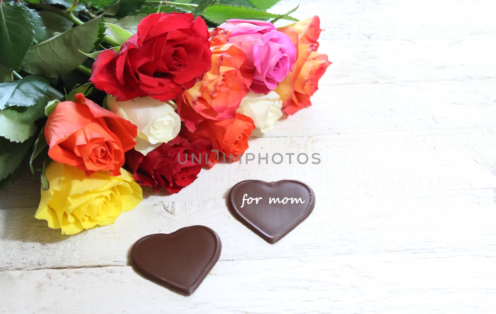 The picture shows colourful roses and chocolate hearts for mother`s day