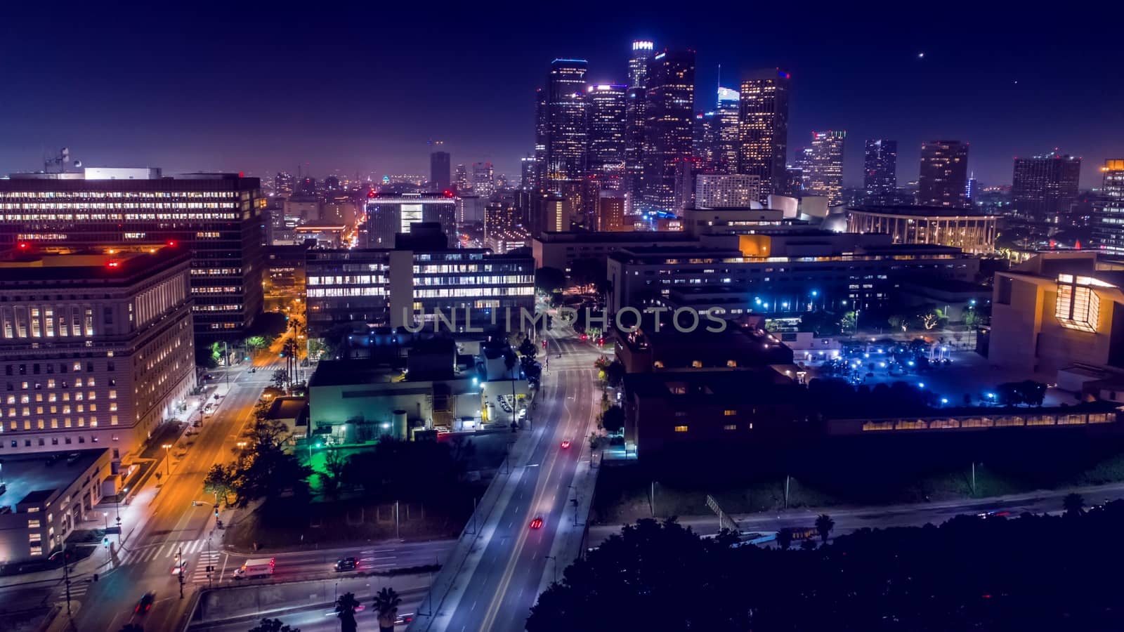 Cinematic aerial view of urban downtown Los Angeles city skyline and streets at night by bhavik_jagani