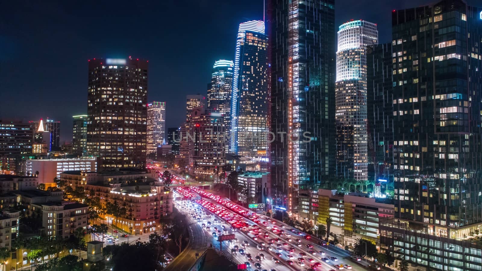 Cinematic aerial view of urban downtown Los Angeles city skyline and streets at night