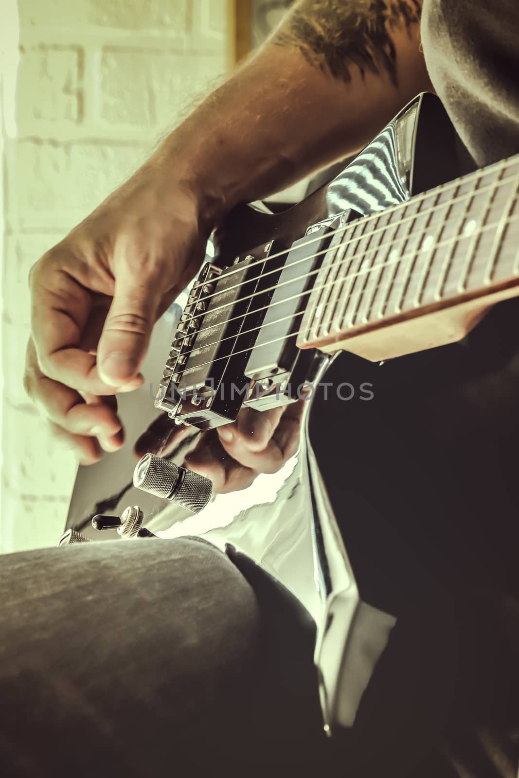 Musical lifestyle background. Playing the guitar. Guitarist's hand dynamic motion. Macro closeup.