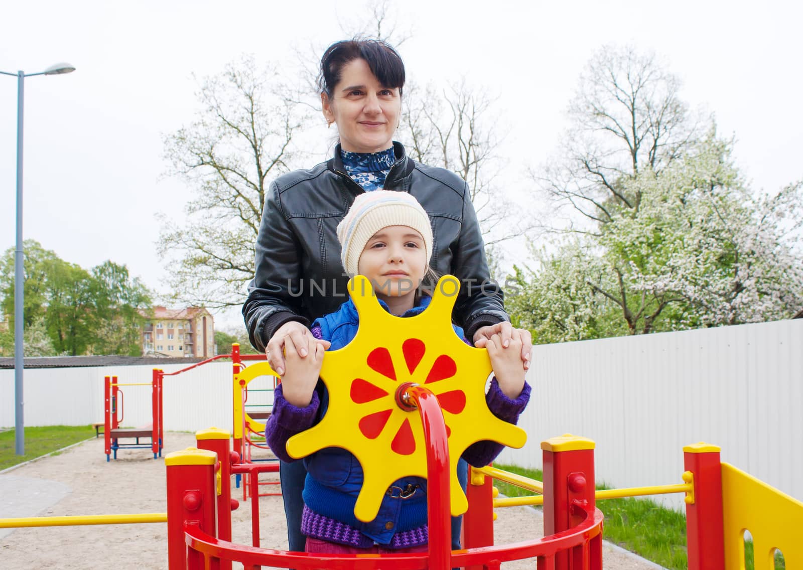 mom plays with her daughter at the playground on a toy ship by raddnatt
