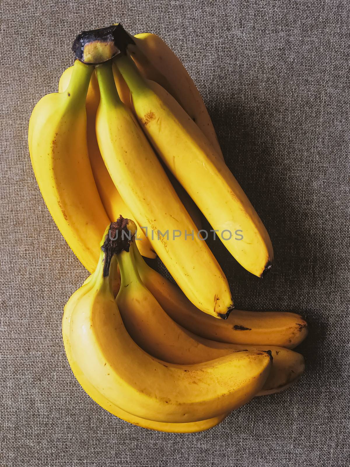 Organic bananas on rustic linen background by Anneleven