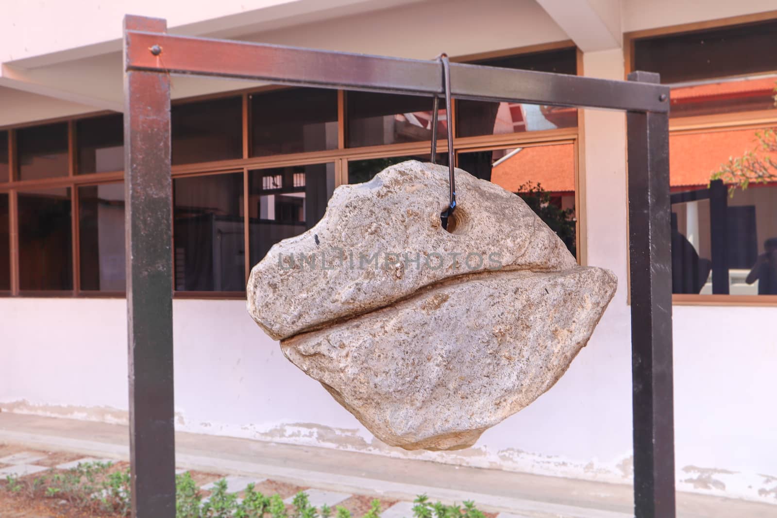 Decorative boulder hanging on a chain in Buddhist temple, Thailand. Lucky rock harmony and stability concept.