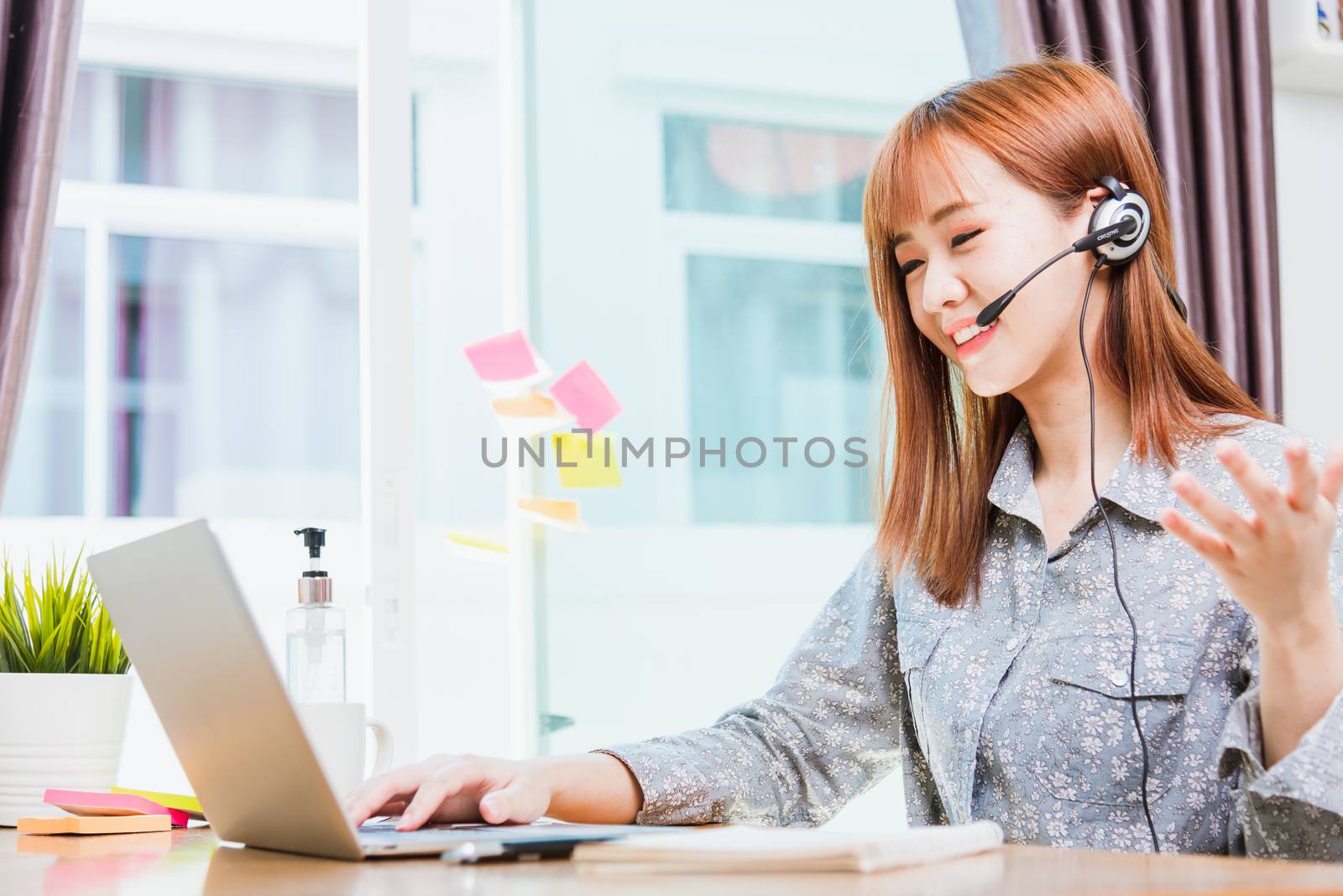Work from home concept, Happy Asian beautiful young business woman wearing headphone call online conference video call meeting for discussion talking with boos and team together by laptop computer