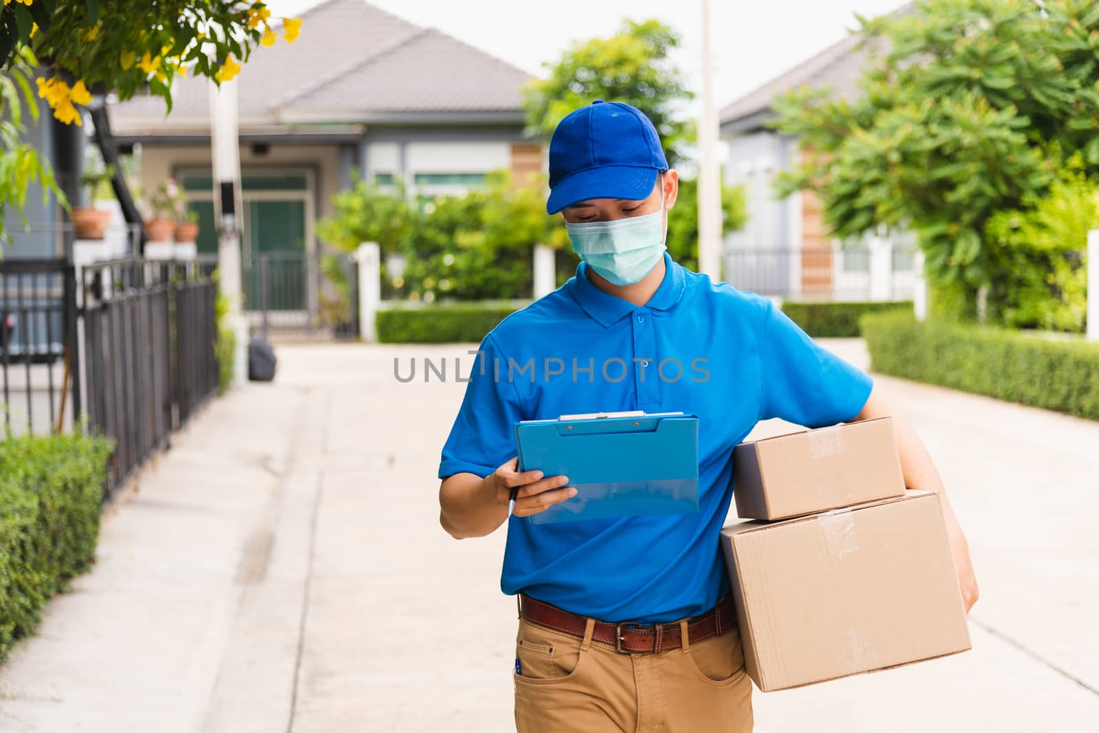 delivery man courier hold parcel post boxes he protective face m by Sorapop