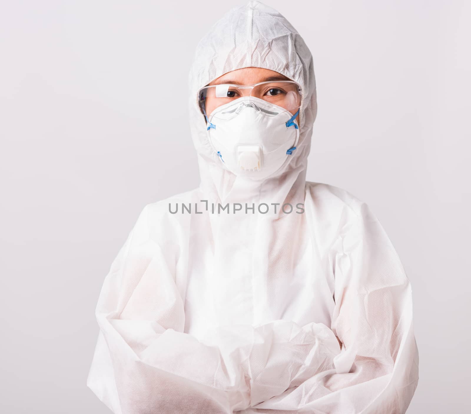 Portrait and closeup Asian female woman doctor or nurse in PPE uniform and gloves wearing face mask protective stand crossed arm in laboratory holding, Health medical coronavirus or COVID-19 concept