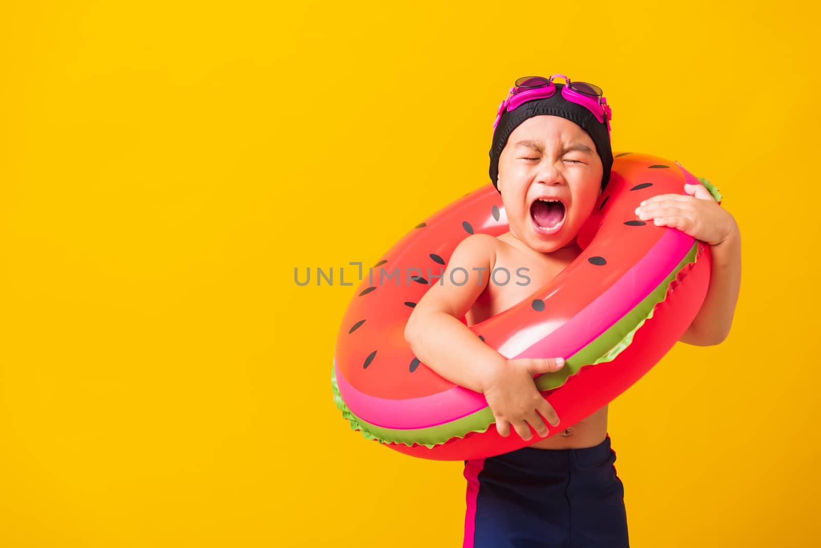 Child boy wearing goggles and swimsuit holding beach watermelon  by Sorapop