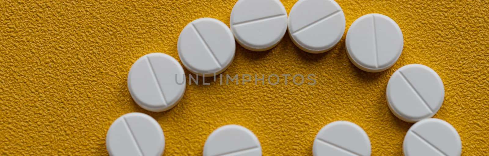 Trendy pattern made with Pharmaceutical medicine pills, tablets and capsules on bright light yellow background. Medicine creative concepts. Minimal style with colorful paper backdrop.