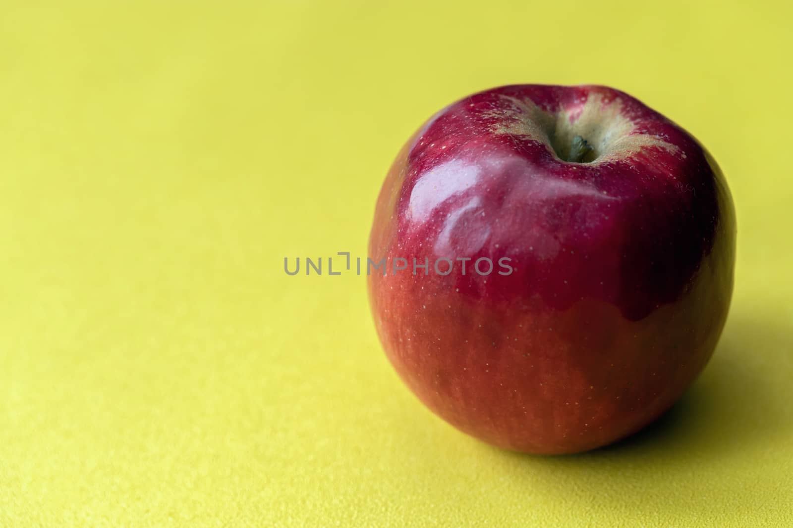 Red fresh Apple on a yellow background, isolate, free copy space for your text