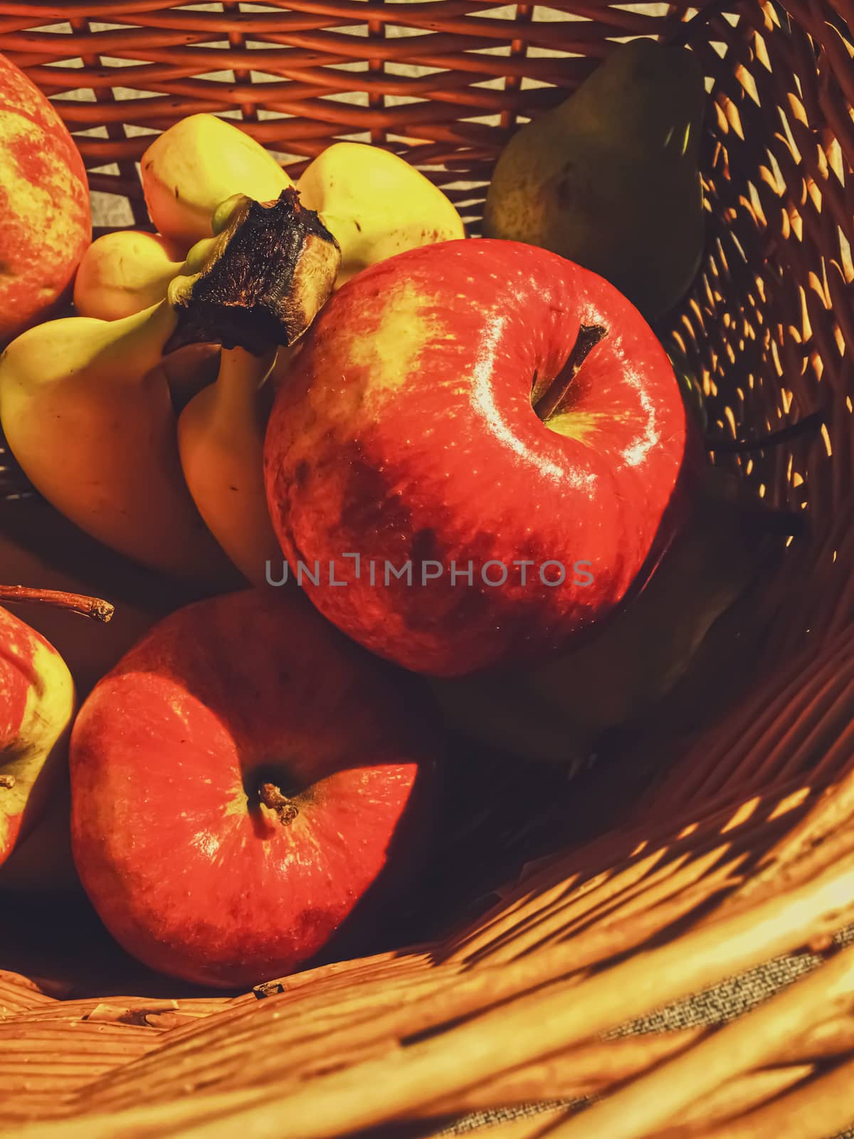 Organic apples, pears and bananas on rustic in a wicker basket, fruits farming and agriculture