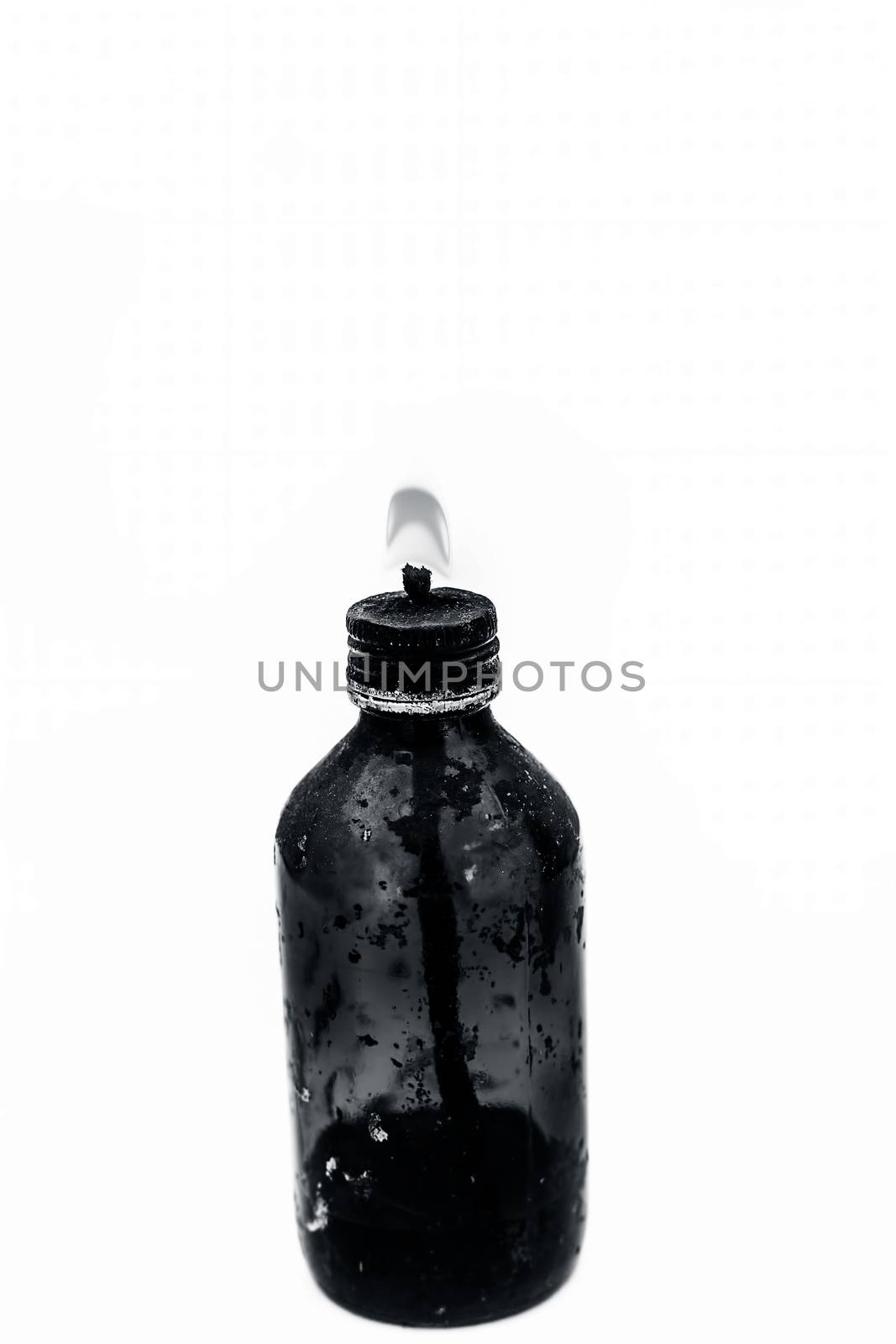 Close up of a bottle shaped kerosene lamp or oil lantern isolated on white burning. by mirzamlk