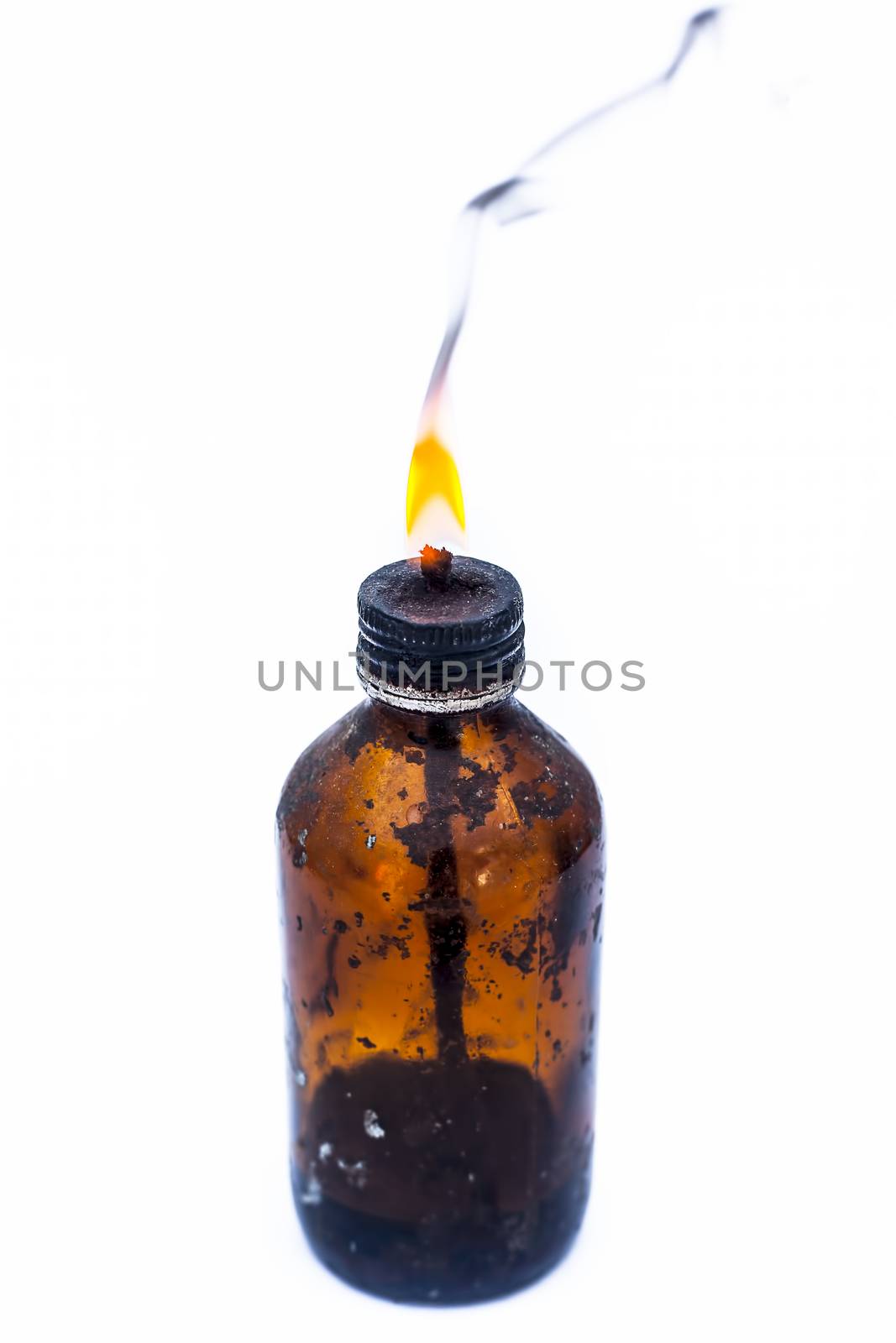 Close up of a bottle shaped kerosene lamp or oil lantern isolated on white burning.