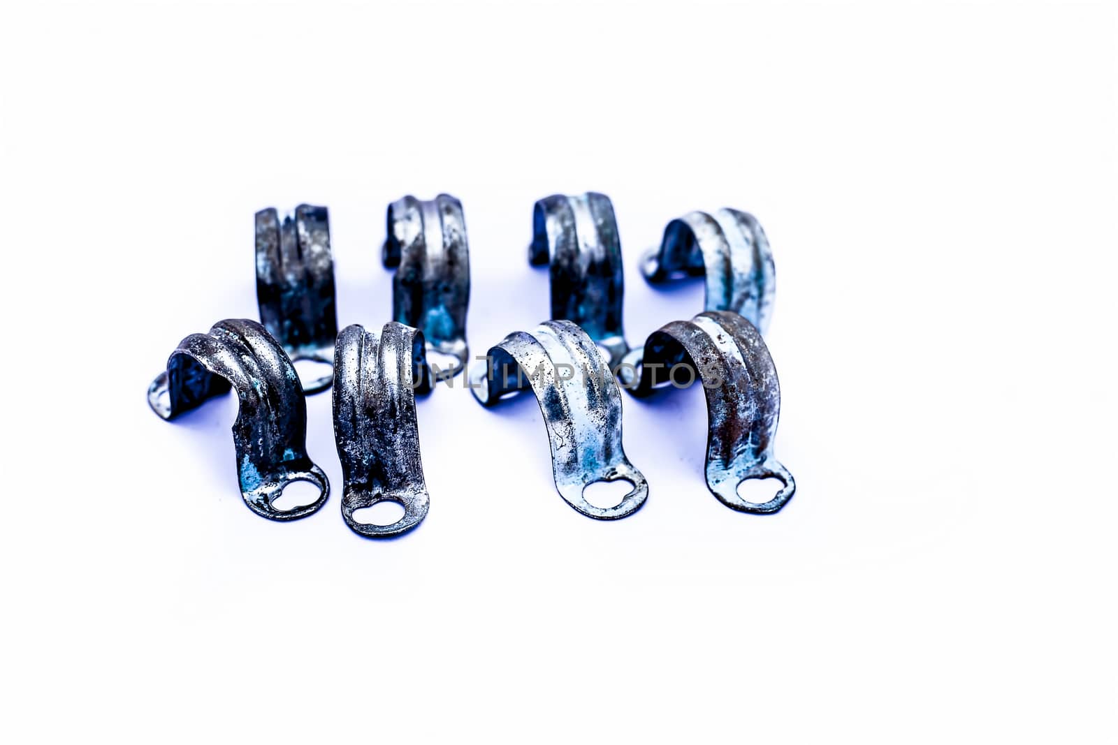 Close up of bunch of aluminum pipe clamp or clip isolated on white. by mirzamlk