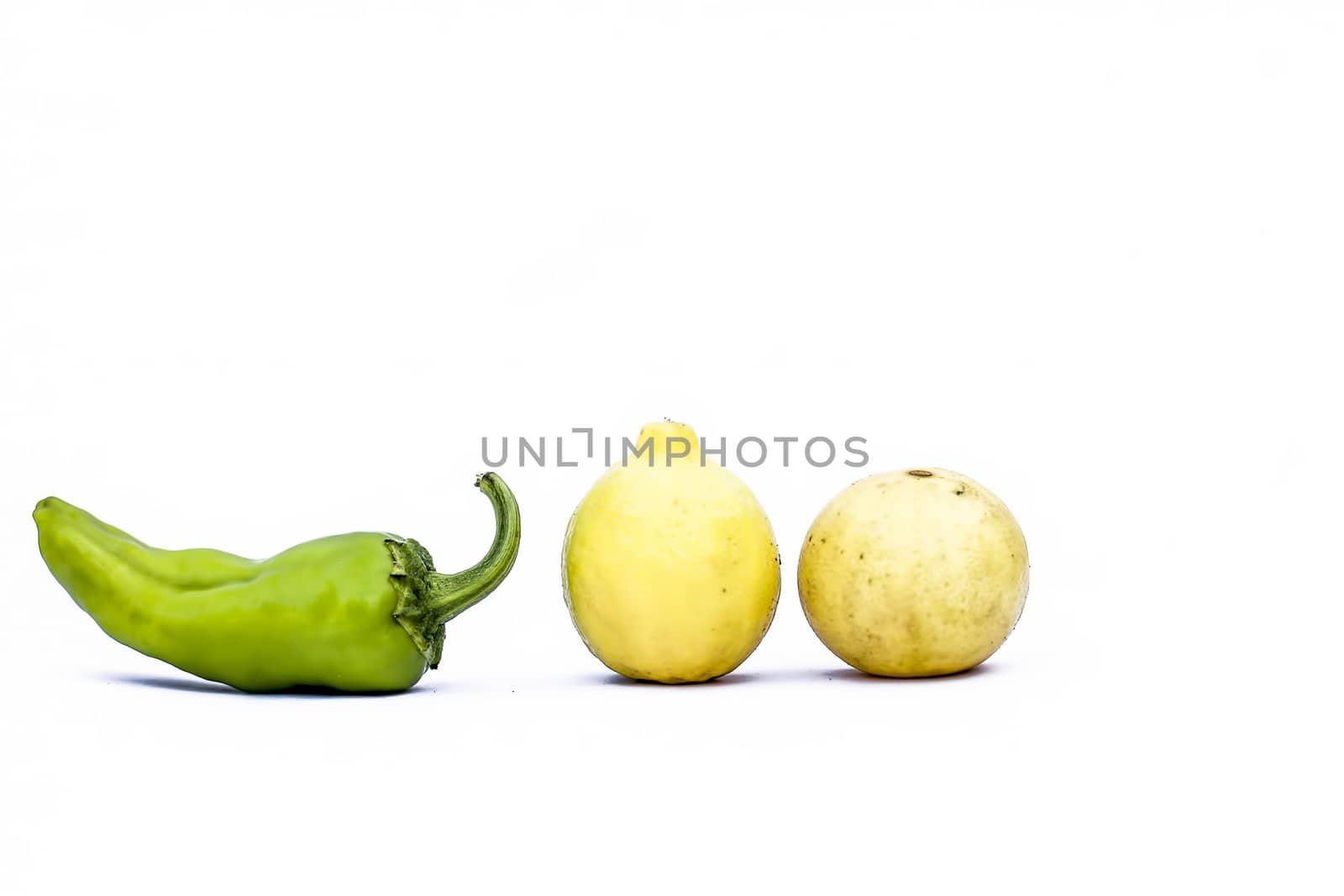 Close up of fresh raw Lemon and chilies isolated on white.