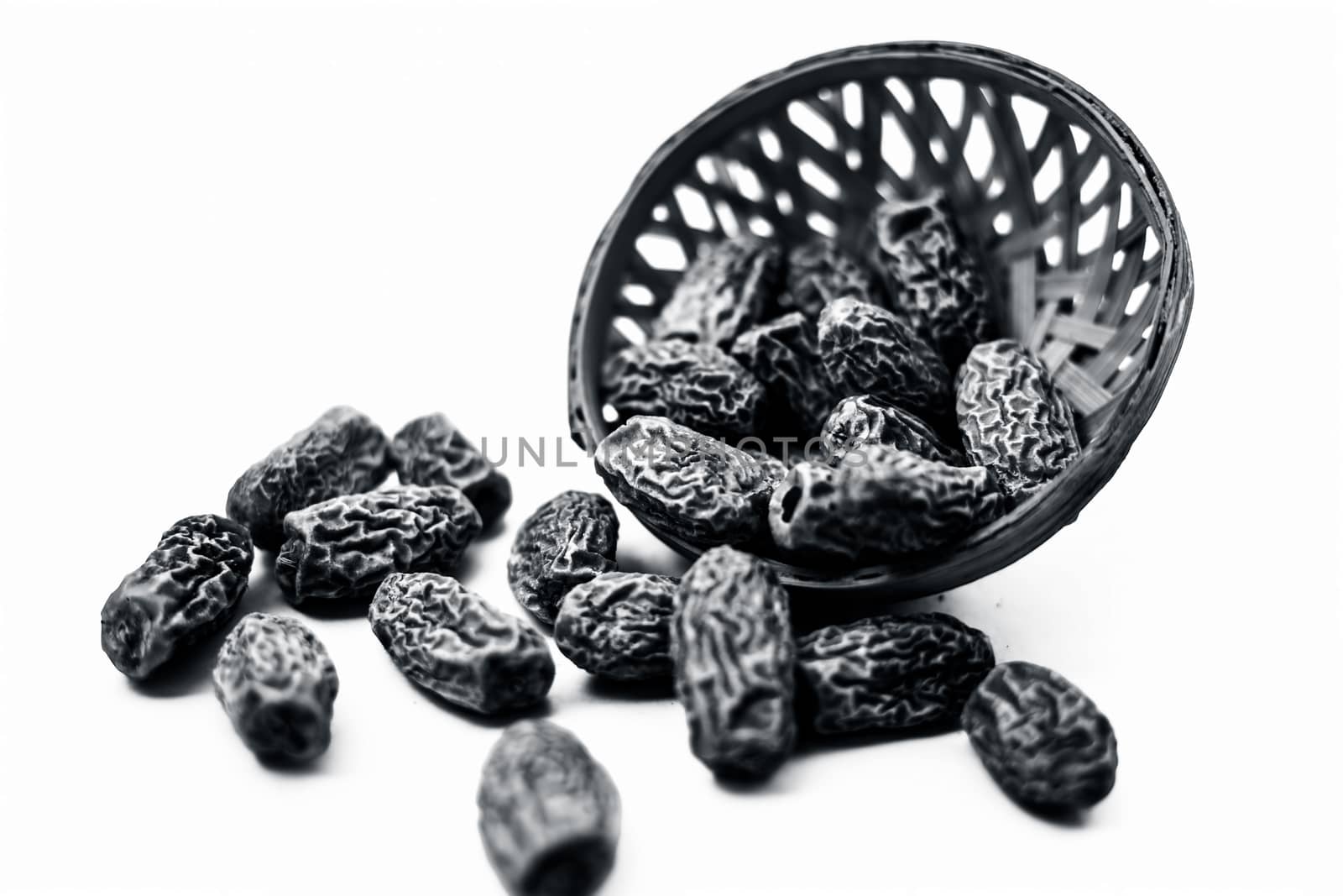 Close up shot of raw dried dates or kharek or sukhi khajoor or Phoenix dactylifera in a hamper isolated on white.