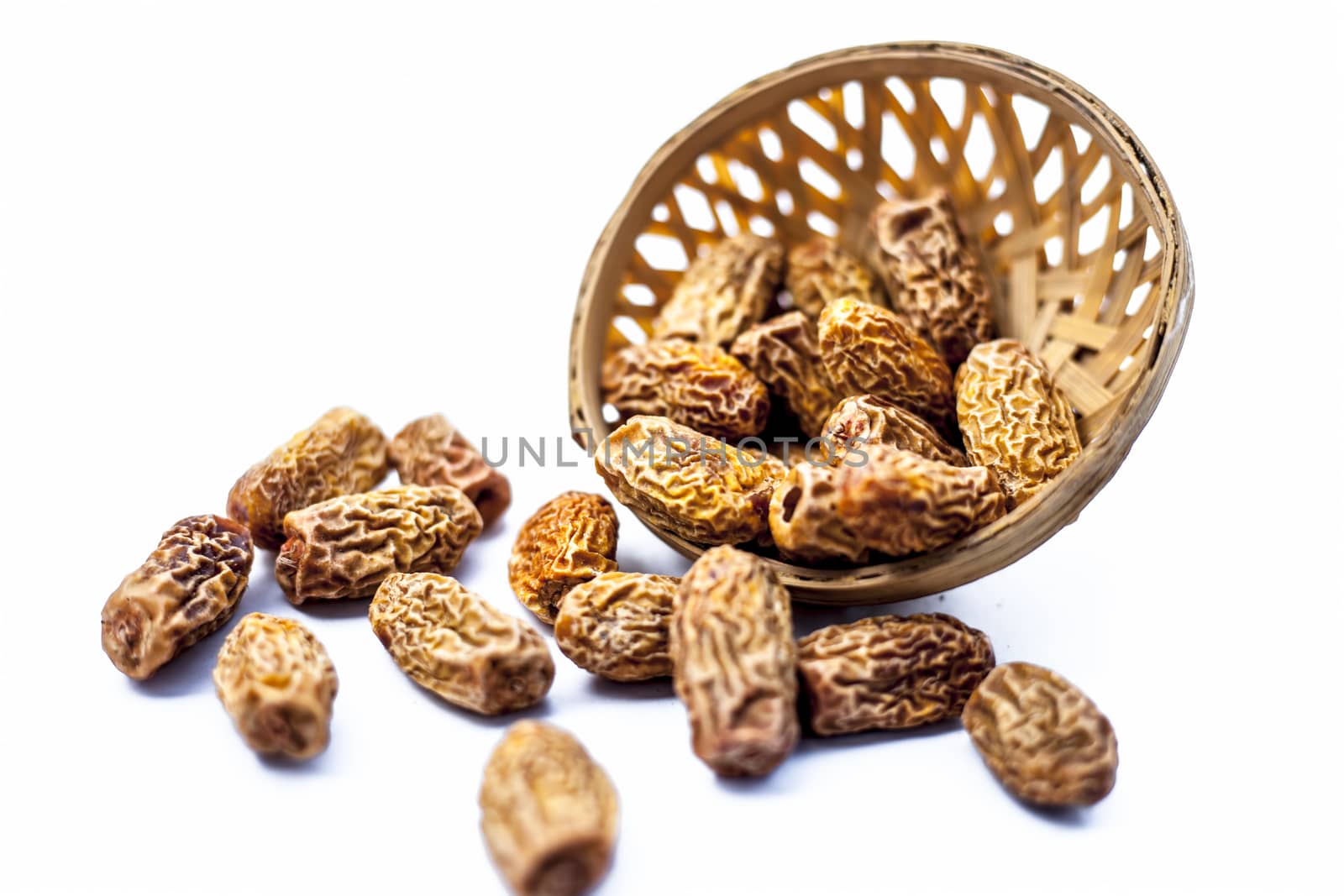 Close up shot of raw dried dates or kharek or sukhi khajoor or Phoenix dactylifera in a hamper isolated on white.