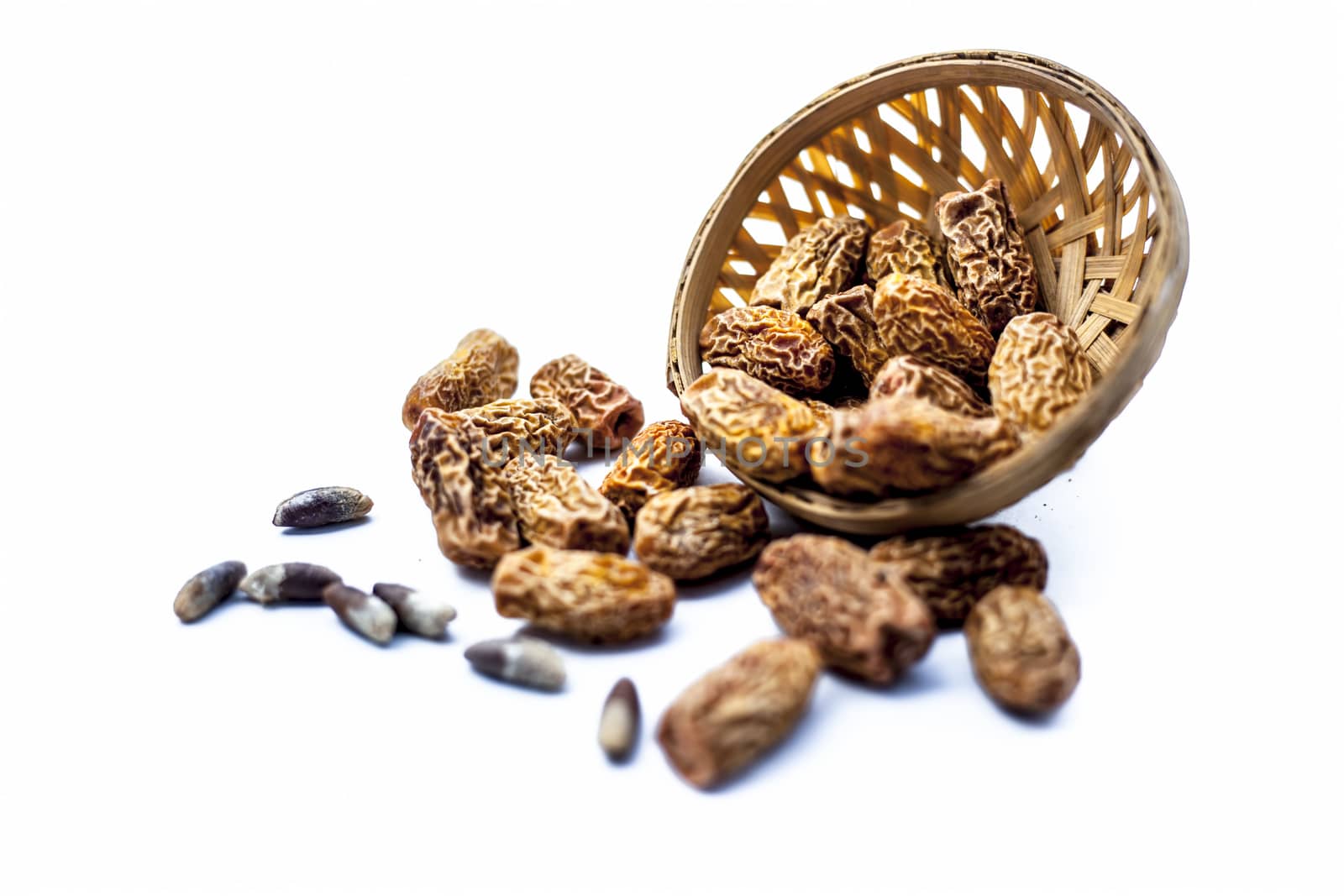 Close up shot of raw dried dates or kharek or sukhi khajoor or Phoenix dactylifera in a hamper isolated on white.