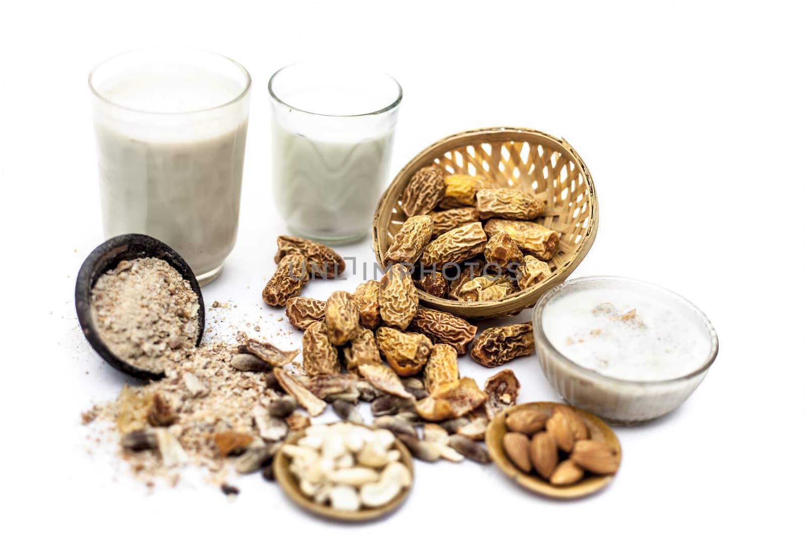 Close up of popular Indian and asian Winter drink isolated on white i.e. Kharek ka dudh or dried dates milk consisting of milk,dried dates,cashews,almonds dry fruits and sugar.