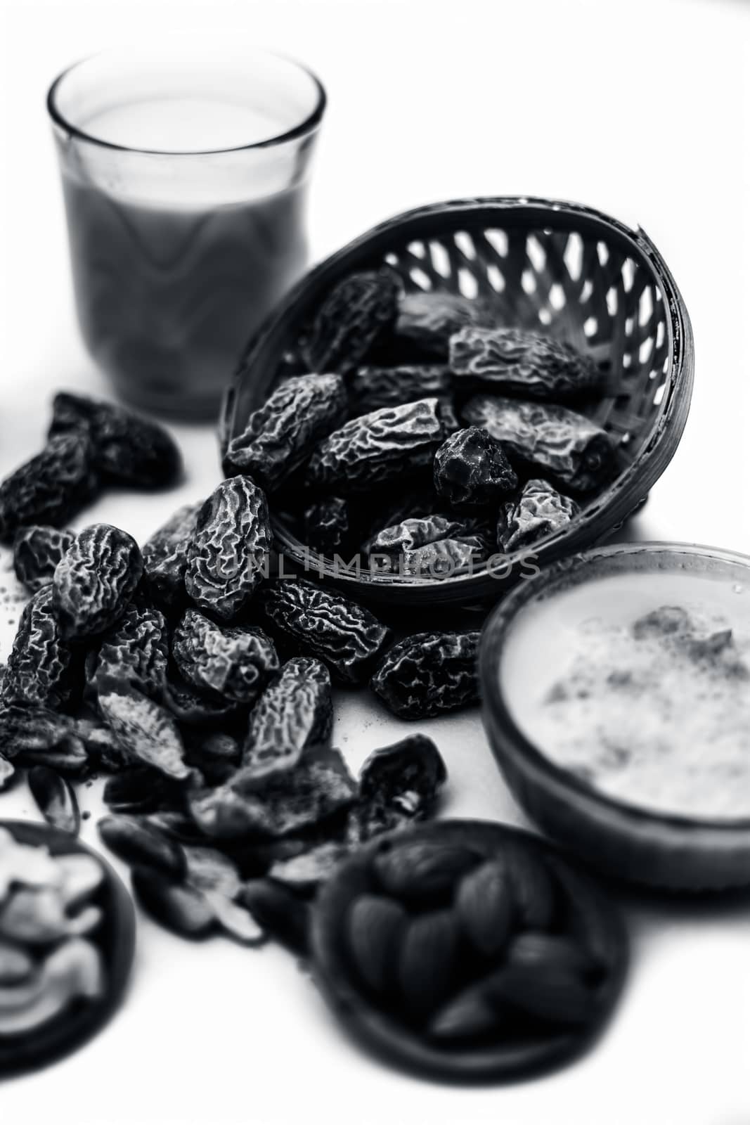 Close up of popular Indian and asian Winter drink isolated on white i.e. Kharek ka dudh or dried dates milk consisting of milk,dried dates,cashews,almonds dry fruits and sugar.