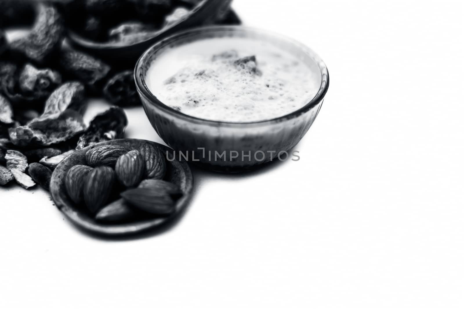 Close up of popular Indian and asian Winter drink isolated on white i.e. Kharek ka dudh or dried dates milk consisting of milk,dried dates,cashews,almonds dry fruits and sugar.