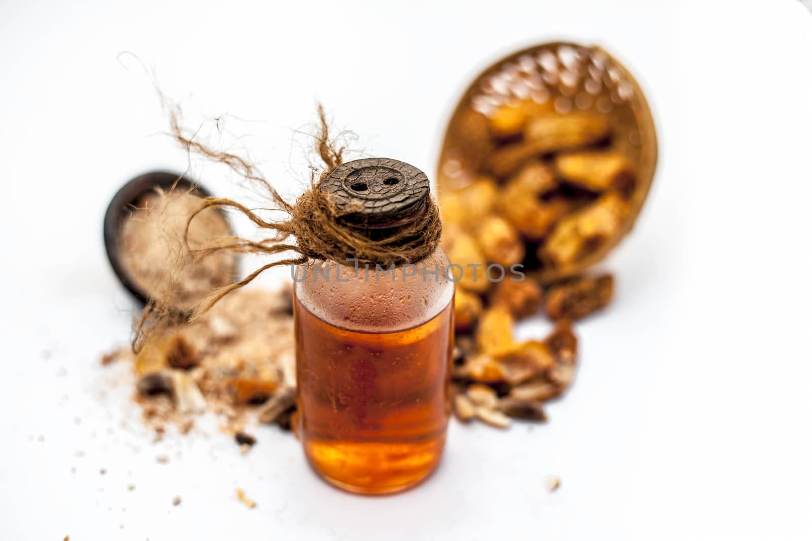 Raw organic dried dates in a hamper with its extracted oil and its powder in a clay bowl isolated on white which widely used in flavored beverages almost entire Asia. by mirzamlk