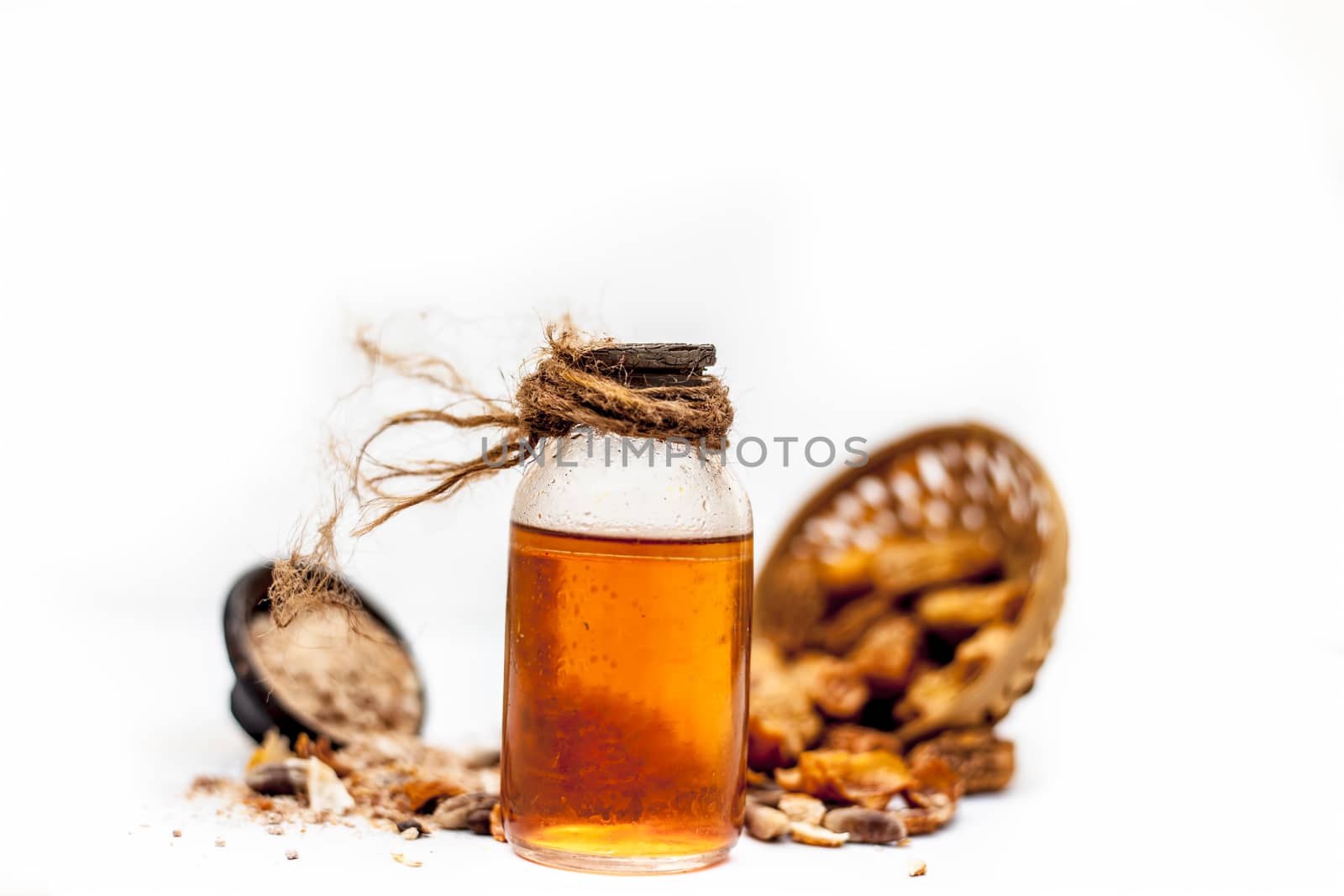 Raw organic dried dates in a hamper with its extracted oil and its powder in a clay bowl isolated on white which widely used in flavored beverages almost entire Asia. by mirzamlk