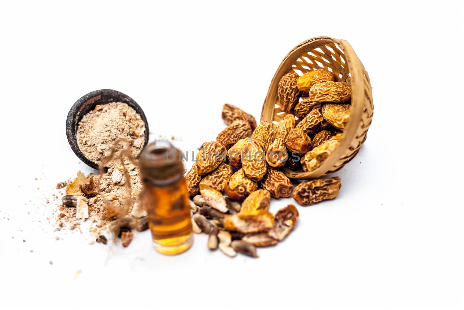 Essential oil of kharek of dried dates or sukhi khajoor or Phoenix dactylifera in a transparent glass bottle isolated on white with raw dried dates and its powder.