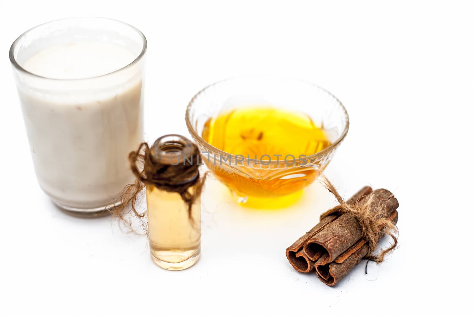 Close up of popular Indian &amp; Asian winter drink isolated on white i.e Honey milk or shahad ka dudh in a transparent glass with entire ingredients which are milk,honey, and dry fruits.