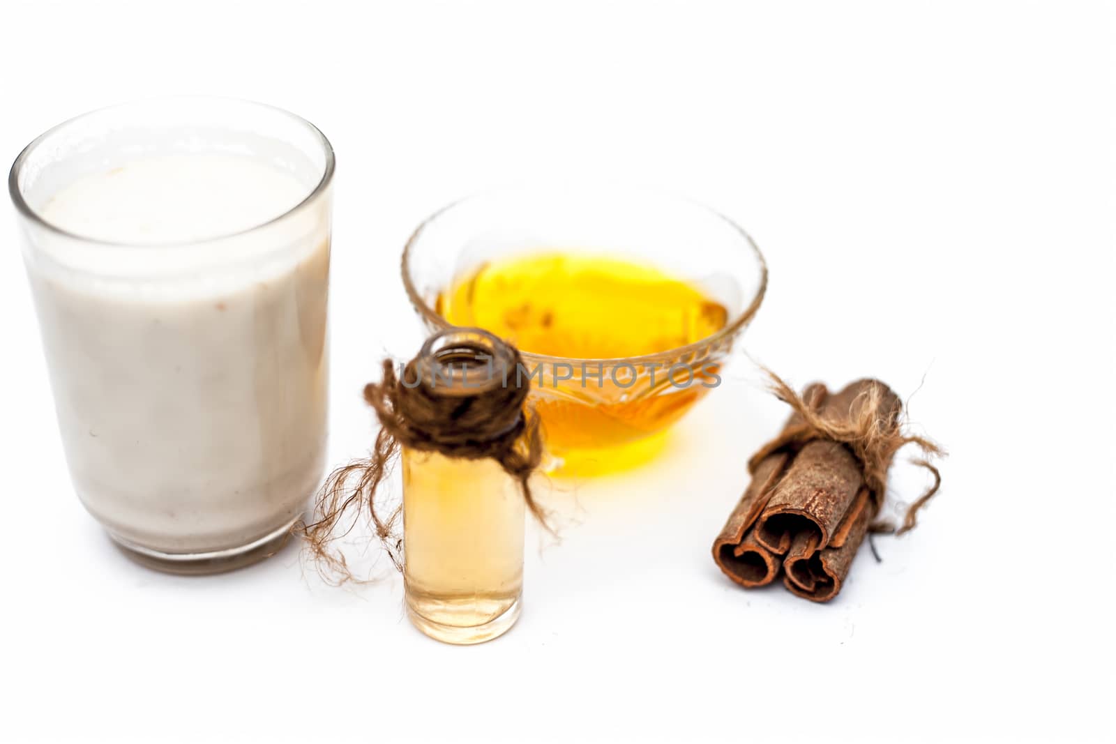 Close up of popular Indian &amp; Asian winter drink isolated on white i.e Honey milk or shahad ka dudh in a transparent glass with entire ingredients which are milk,honey, and dry fruits. by mirzamlk