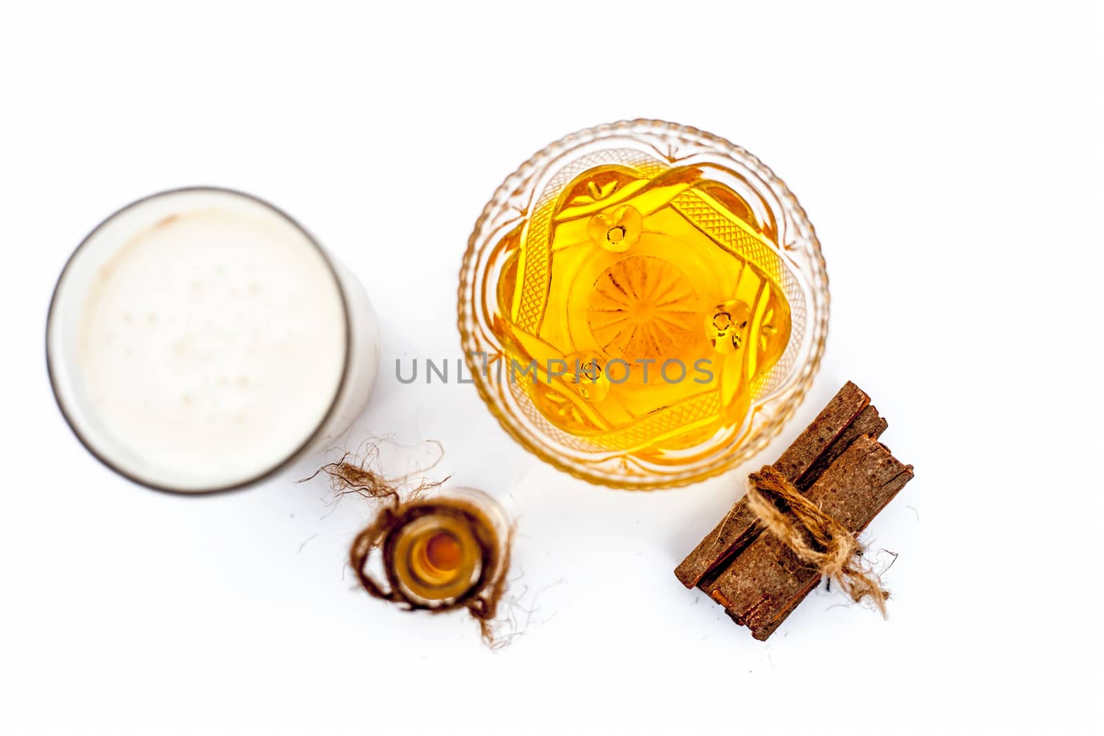 Close up of popular Indian & Asian winter drink isolated on white i.e Honey milk or shahad ka dudh in a transparent glass with entire ingredients which are milk,honey, and dry fruits.