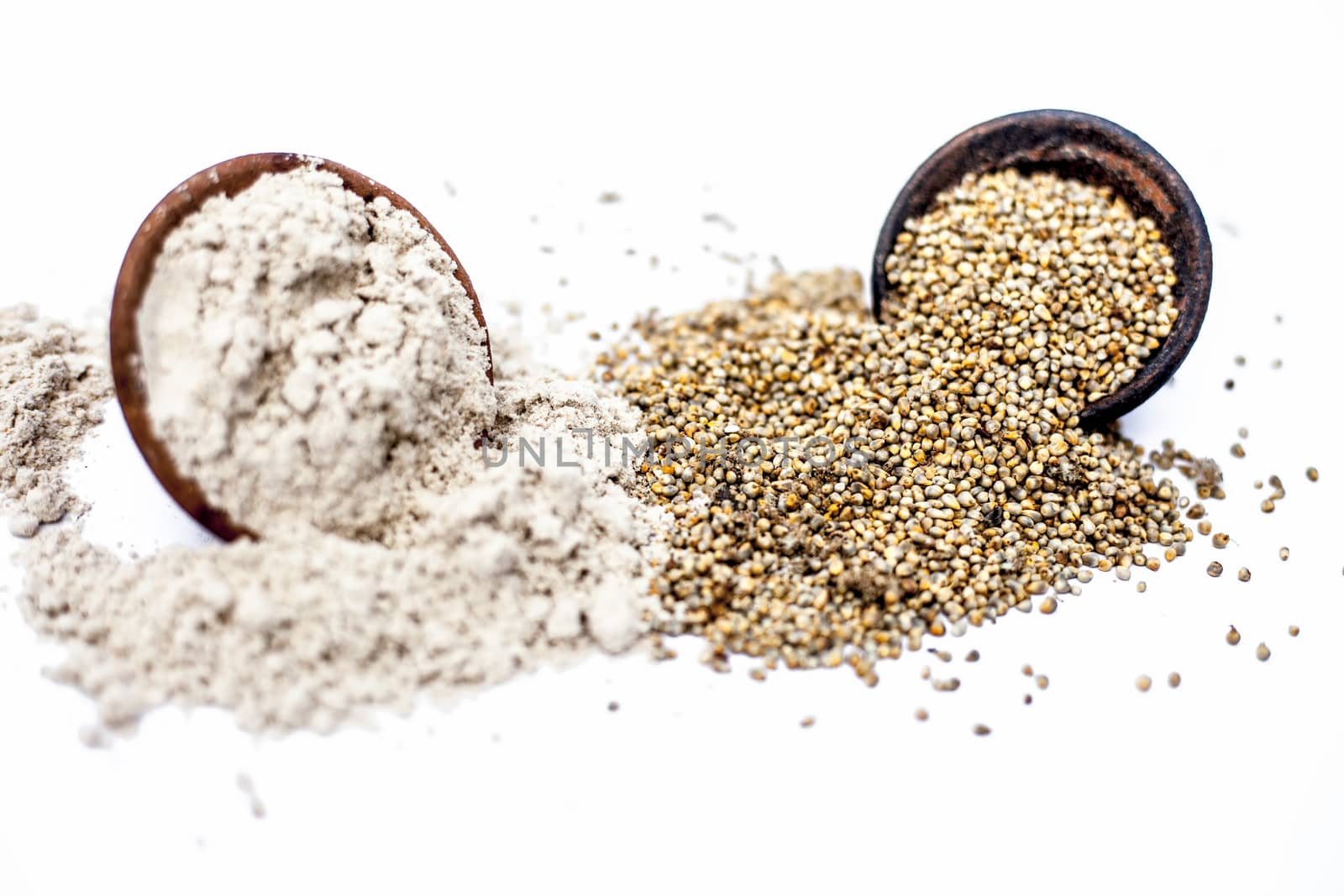 Close up of clay bowl of barley or pearl millet with its flour in a another bowl isolated on white. by mirzamlk