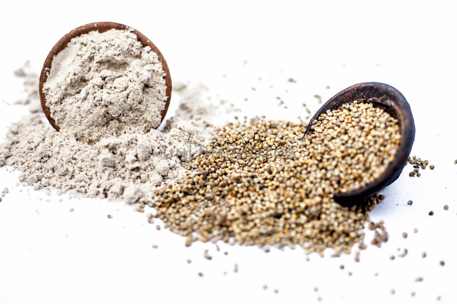 Close up of clay bowl of barley or pearl millet with its flour in a another bowl isolated on white.