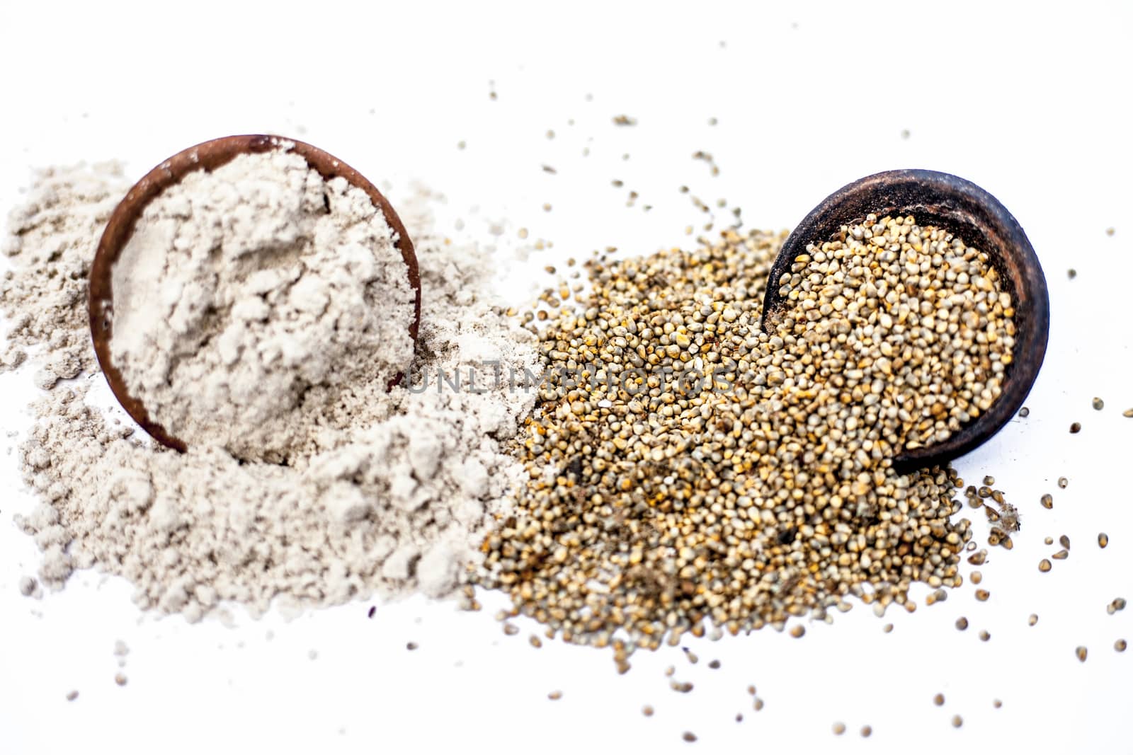 Close up of clay bowl of barley or pearl millet with its flour in a another bowl isolated on white. by mirzamlk