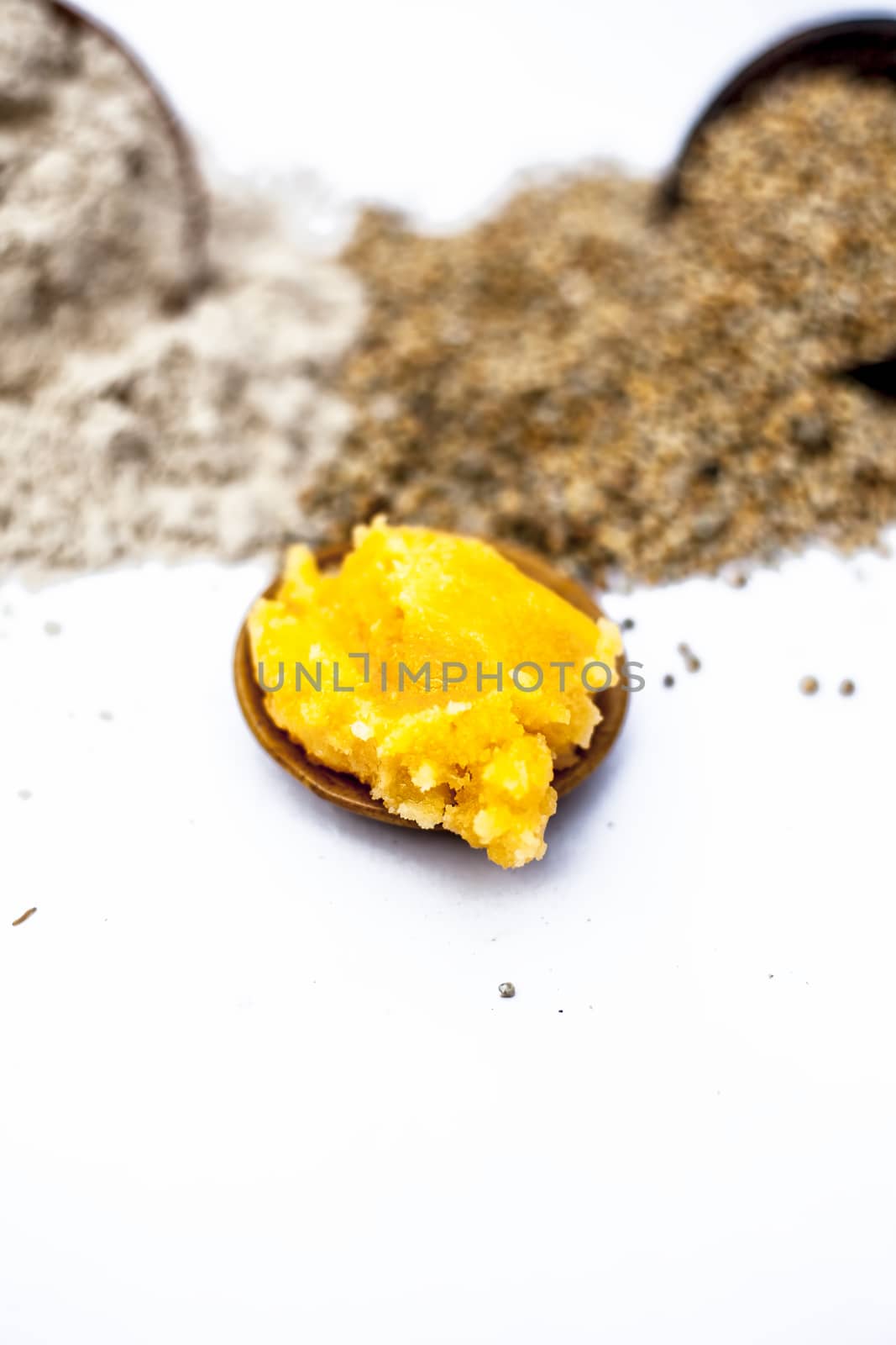 Close up of grain of pearl millet or bajra or bajri in a clay bowl with its flour and jaggery in a small glass plate ingredients for the preparation of sweets for Uttrayan or Makar shankarantri.