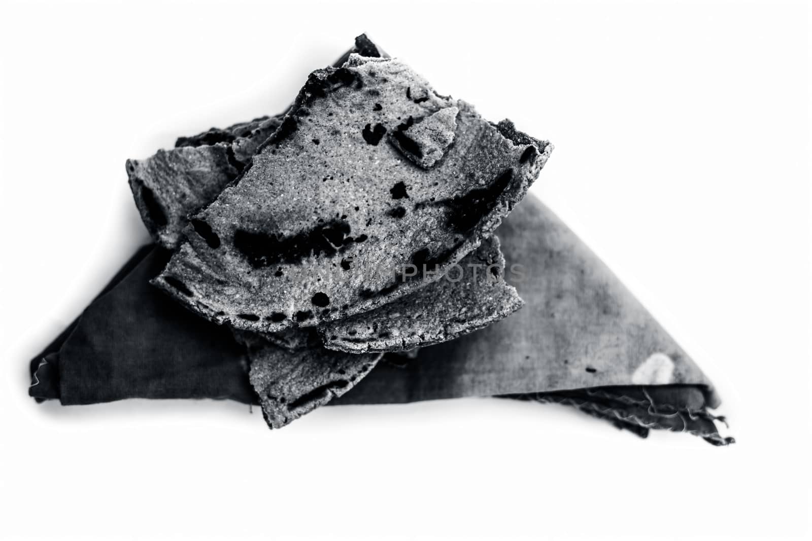 Bajri ki roti or pearl millet roti or chapati on handkerchief isolated on white.