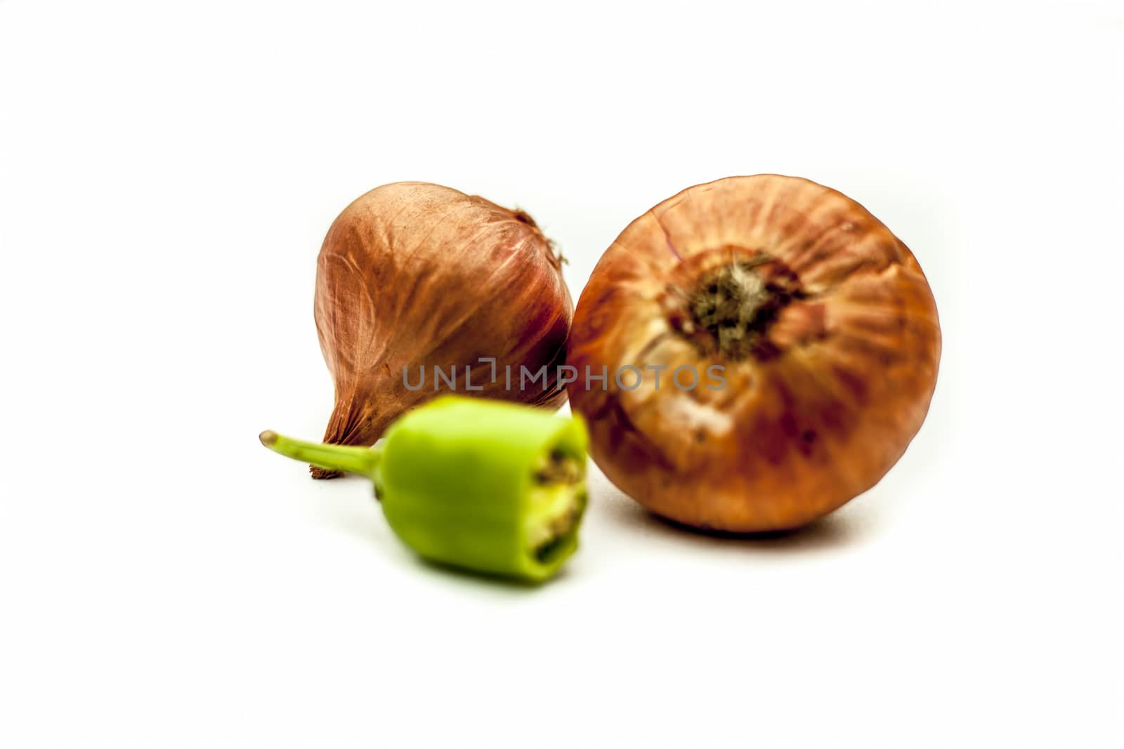 Raw organic two vegetables isolated on white which are onion or pyaaj or pyaaz along with cut chili or hari mirchi or lili mirchi.