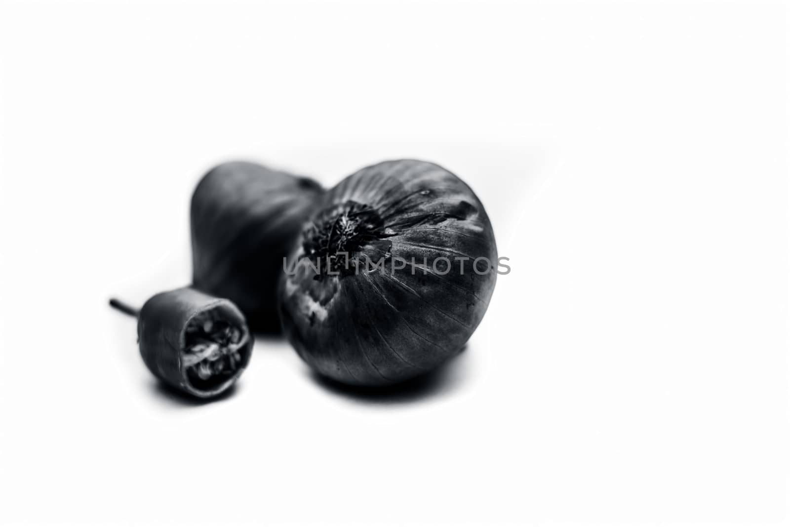 Raw organic two vegetables isolated on white which are onion or pyaaj or pyaaz along with cut chili or hari mirchi or lili mirchi.