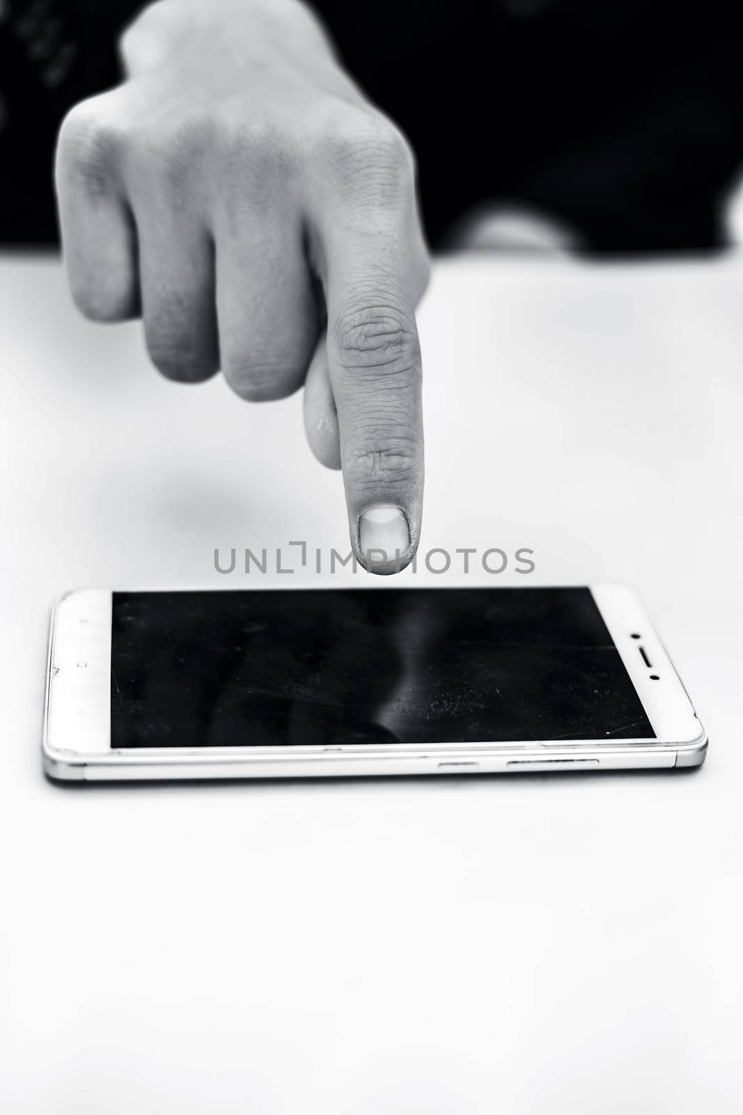 Close up of shot of single hand of a business man wearing a blue colored suit isolated on white using a smart phone with single hand concept of working on a project at a time.