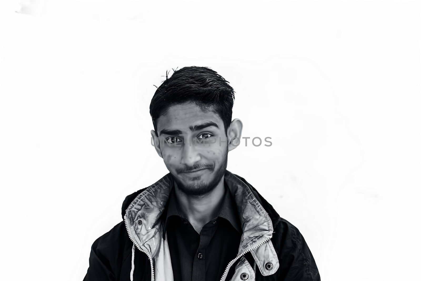 Portrait shot of a young beard man wearing brown colored shirt and a black colored jacket expressing or looking at the camera by surprised face or with curiosity or sometimes hilarious faces.