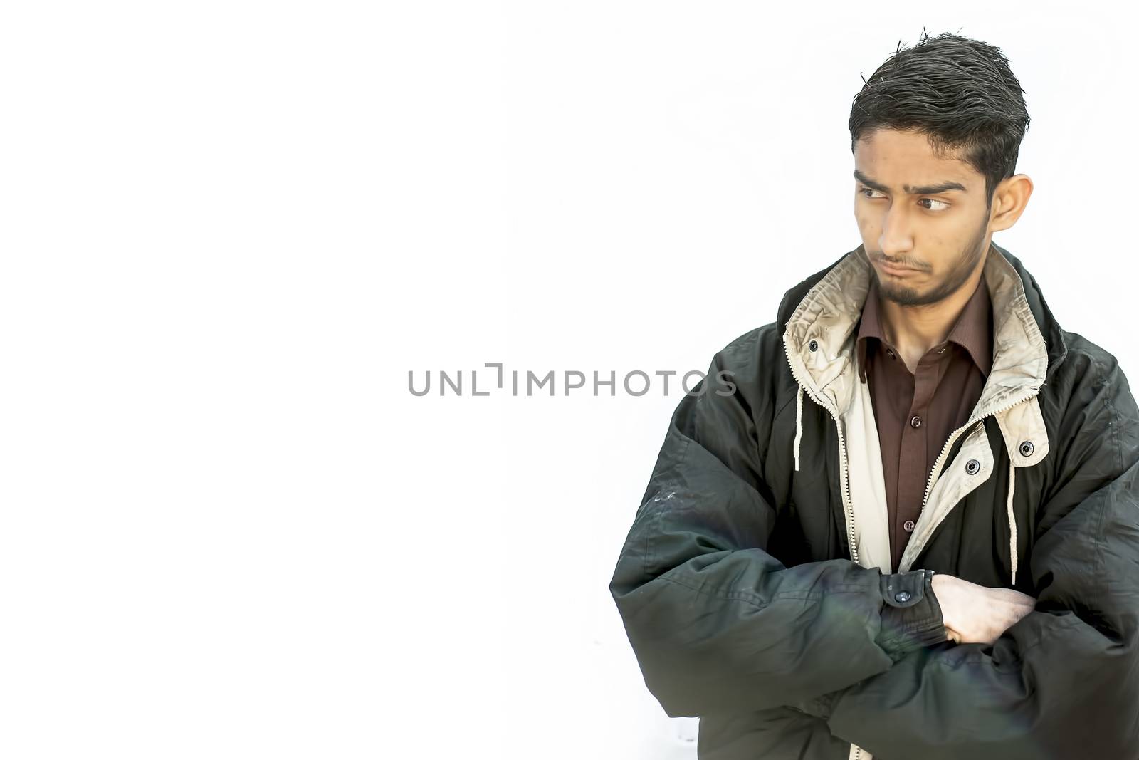 Portrait shot of a young beard man wearing brown colored shirt and a black colored jacket expressing curiousness by looking at the blank side. by mirzamlk