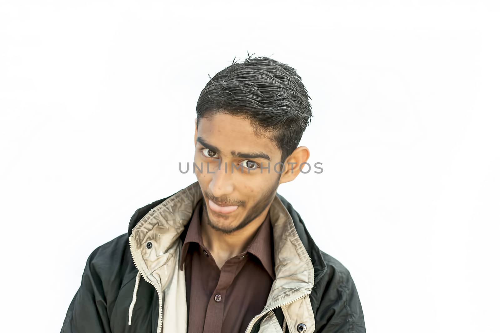 Portrait shot of a young beard man wearing brown colored shirt and a black colored jacket expressing or looking at the camera by surprised face or with curiosity or sometimes hilarious faces. by mirzamlk