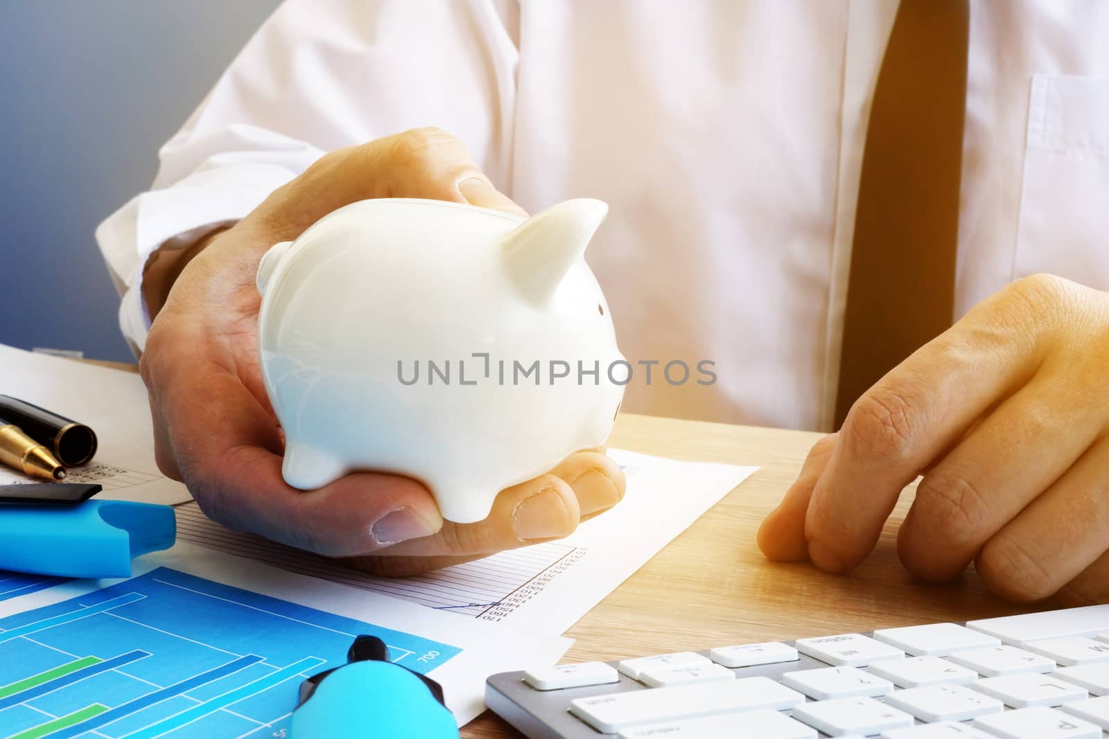 Savings concept. Businessman holding piggy bank. by designer491