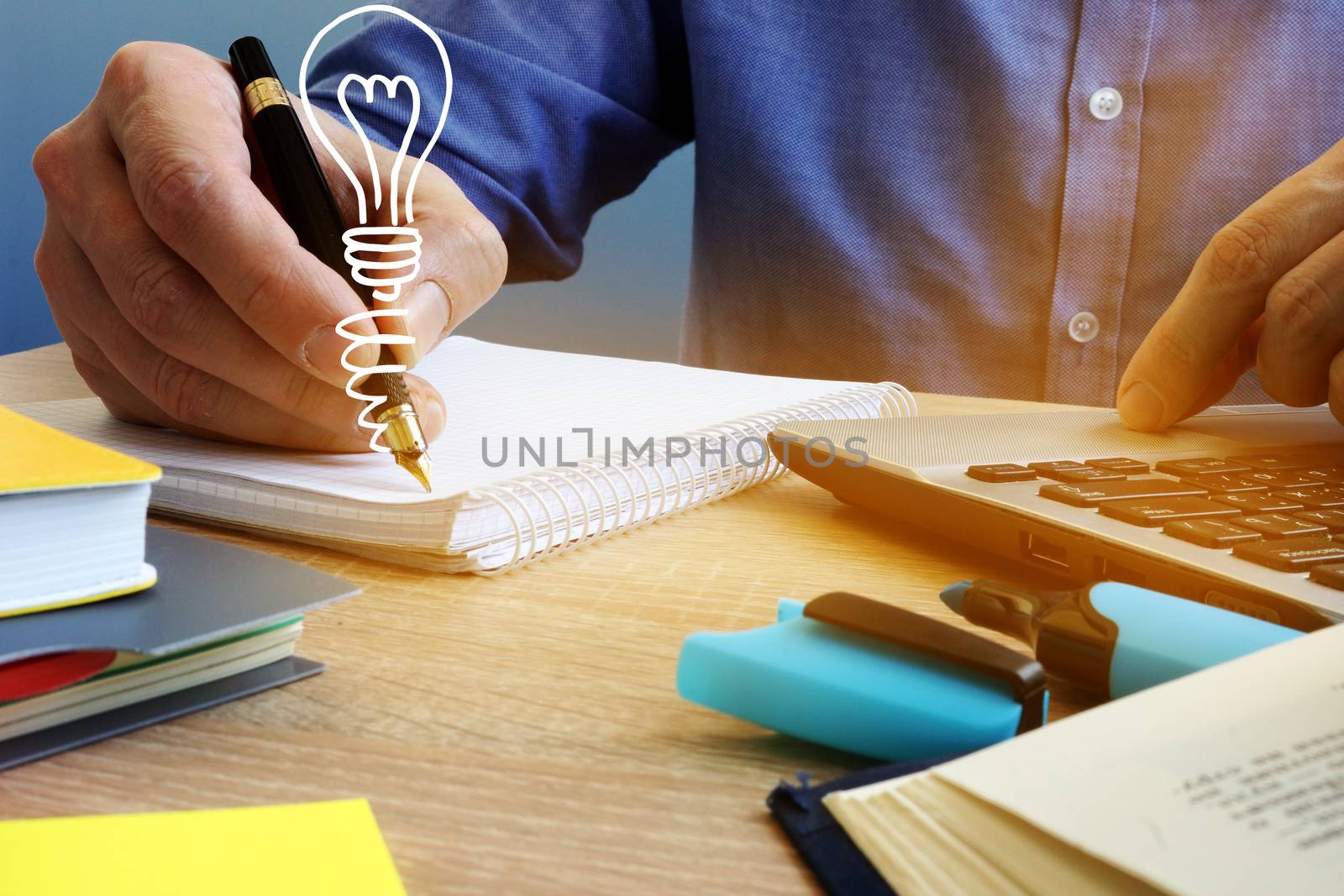 Ideas concept. Businessman writing in the note and light bulb. Creative process.