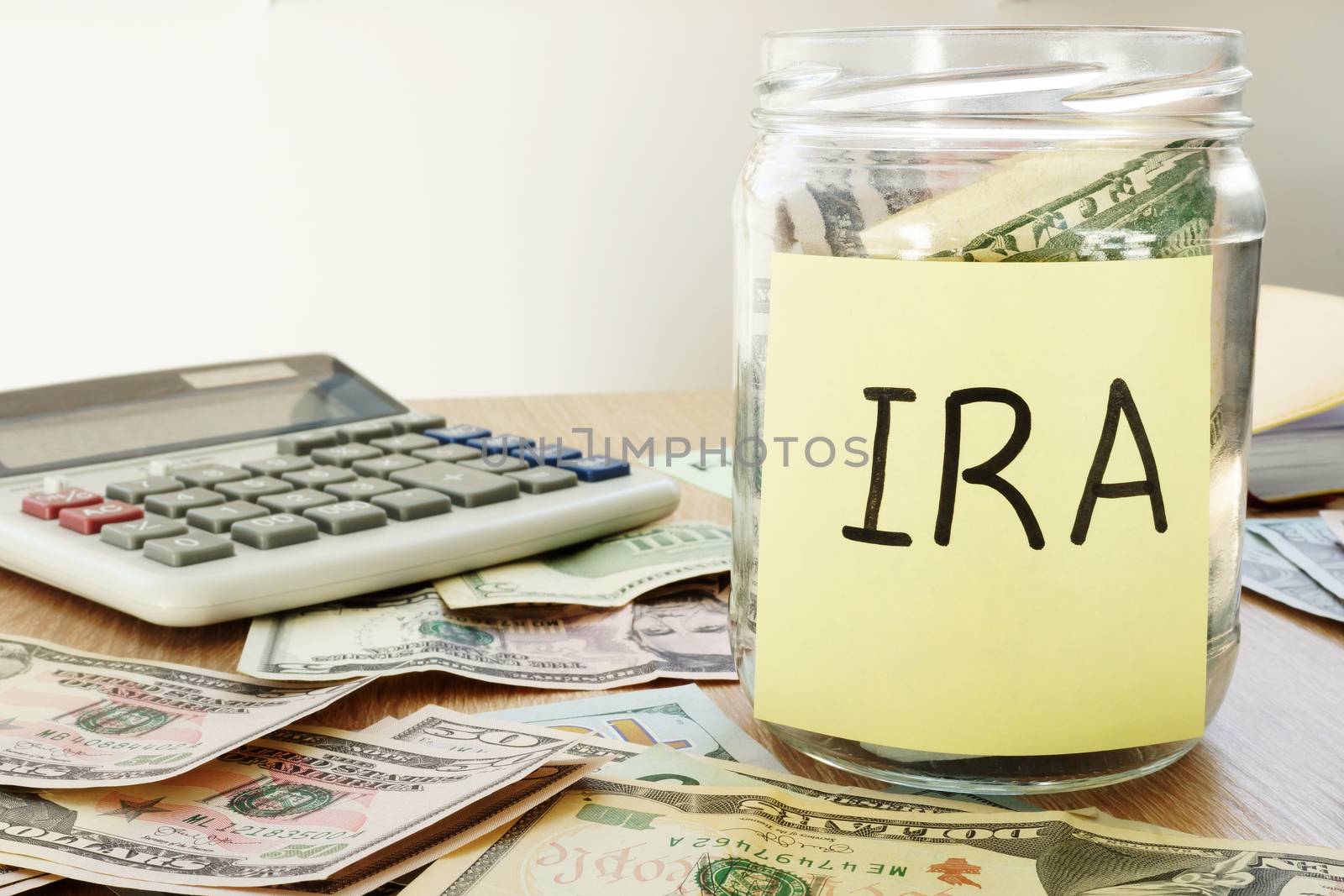 IRA written on a stick and jar with dollars.
