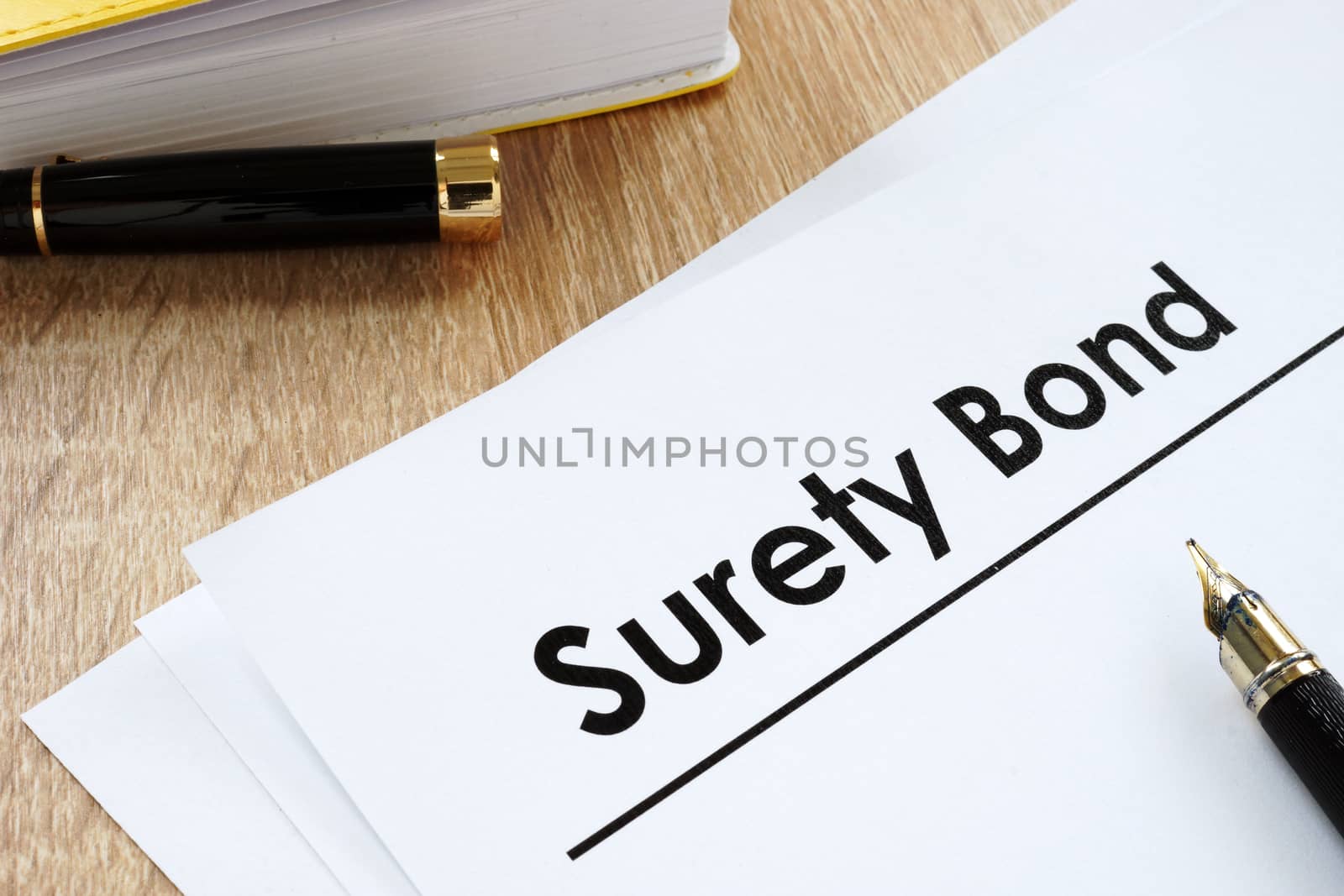 Surety bond form and pen on a table.